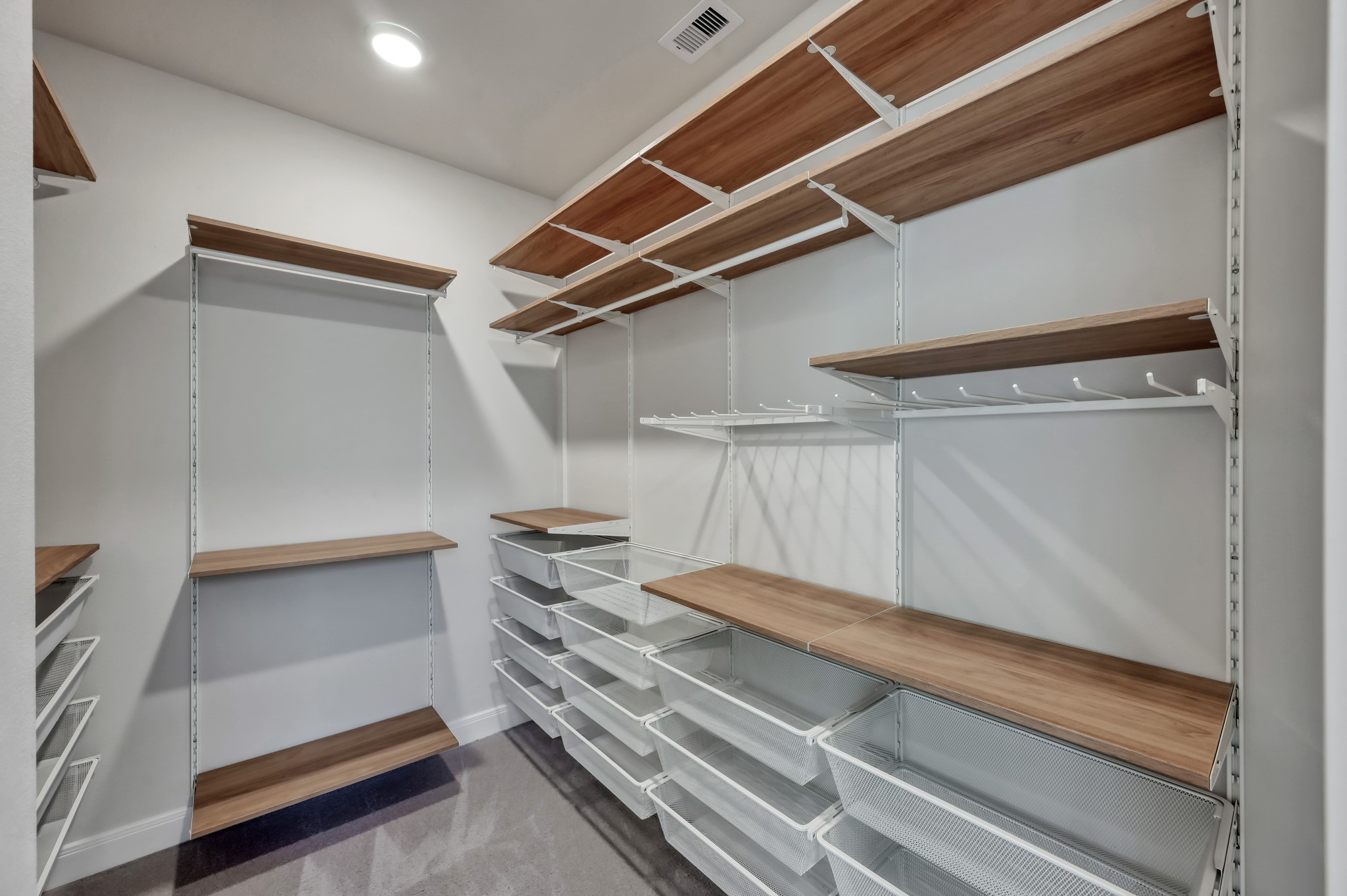 Spacious walk-in closet with custom shelving and built-in storage system.