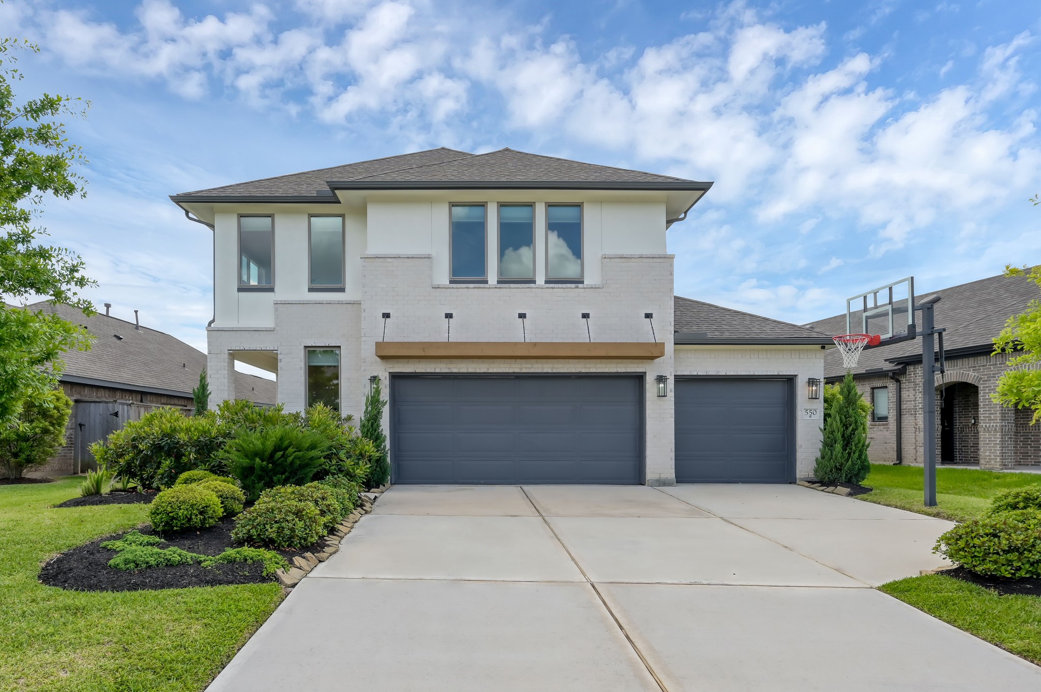 Modern two-story home with clean white brick elevation, 3-car garage, and well-manicured landscaping on a quiet cul-de-sac street. Modern two-story home with clean white brick elevation, 3-car garage, and well-manicured landscaping on a quiet cul-de-sac street.