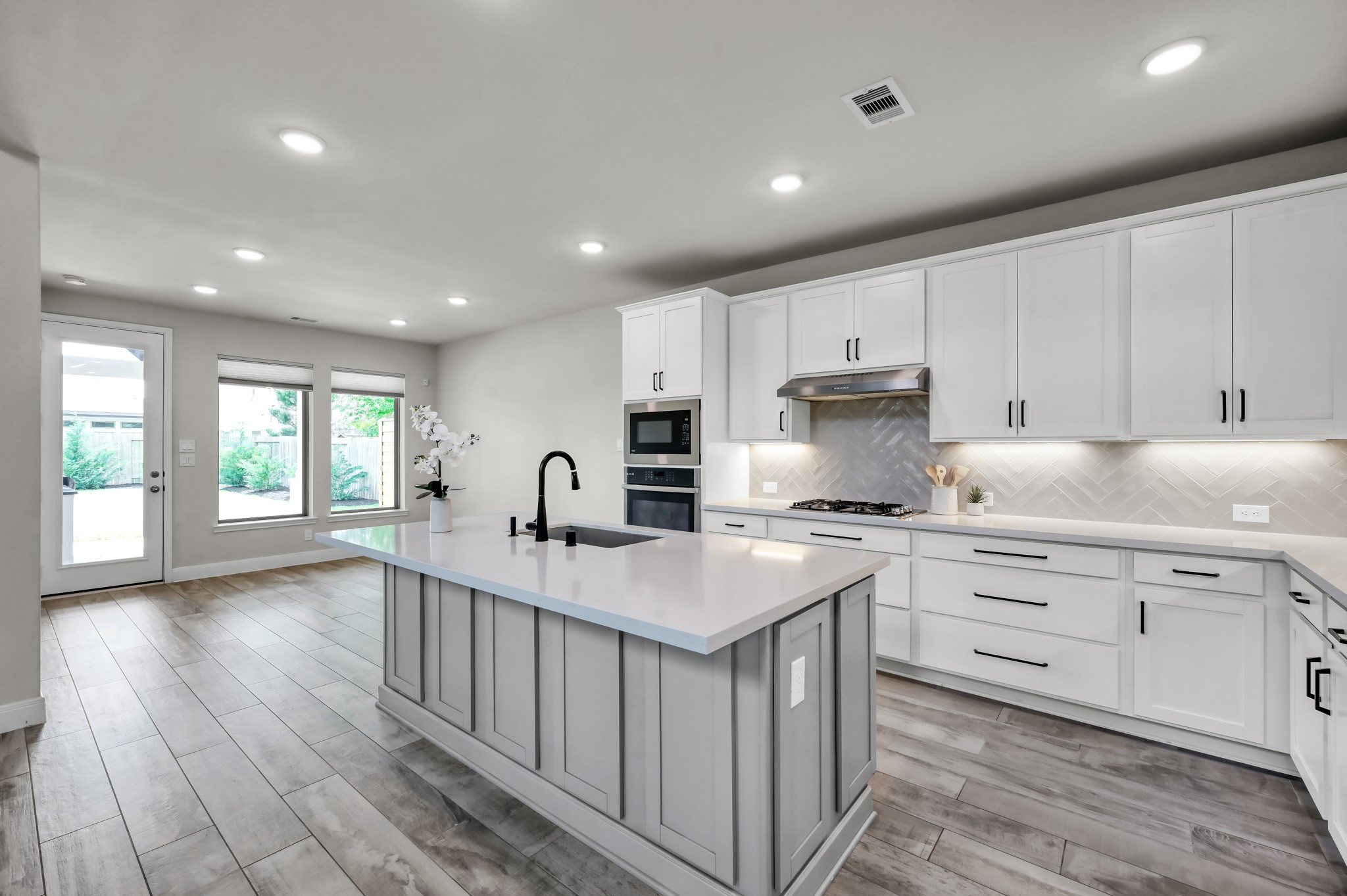 Oversized island with breakfast bar seating and under-cabinet lighting.