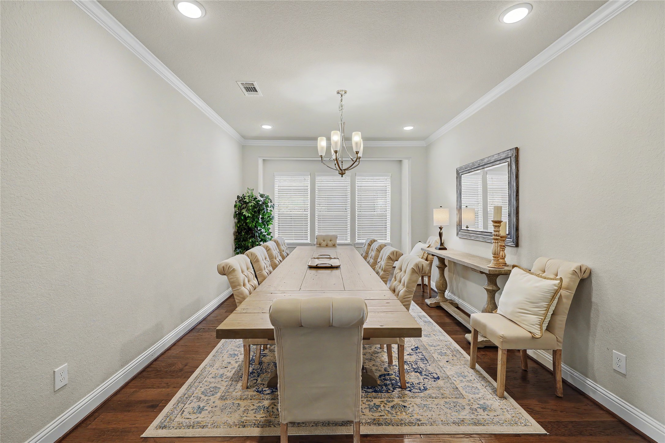 Formal dining room with tray ceiling, chandelier, and wood flooring.