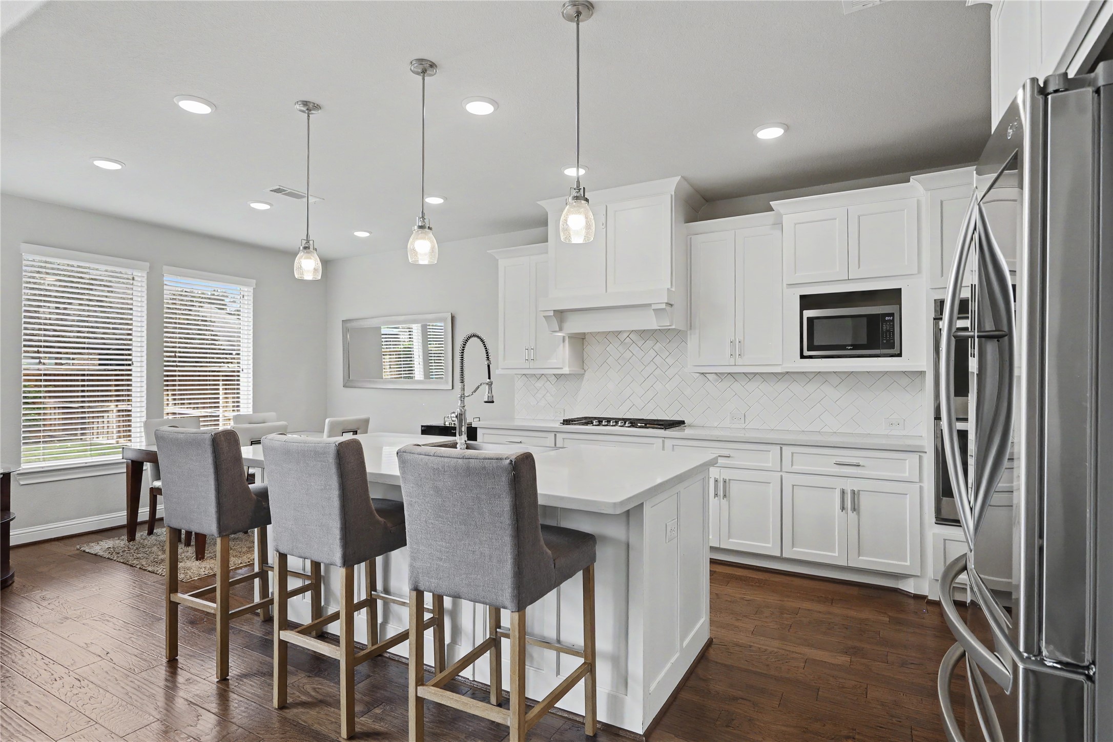 Additional kitchen view featuring island seating and adjacent living spaces.