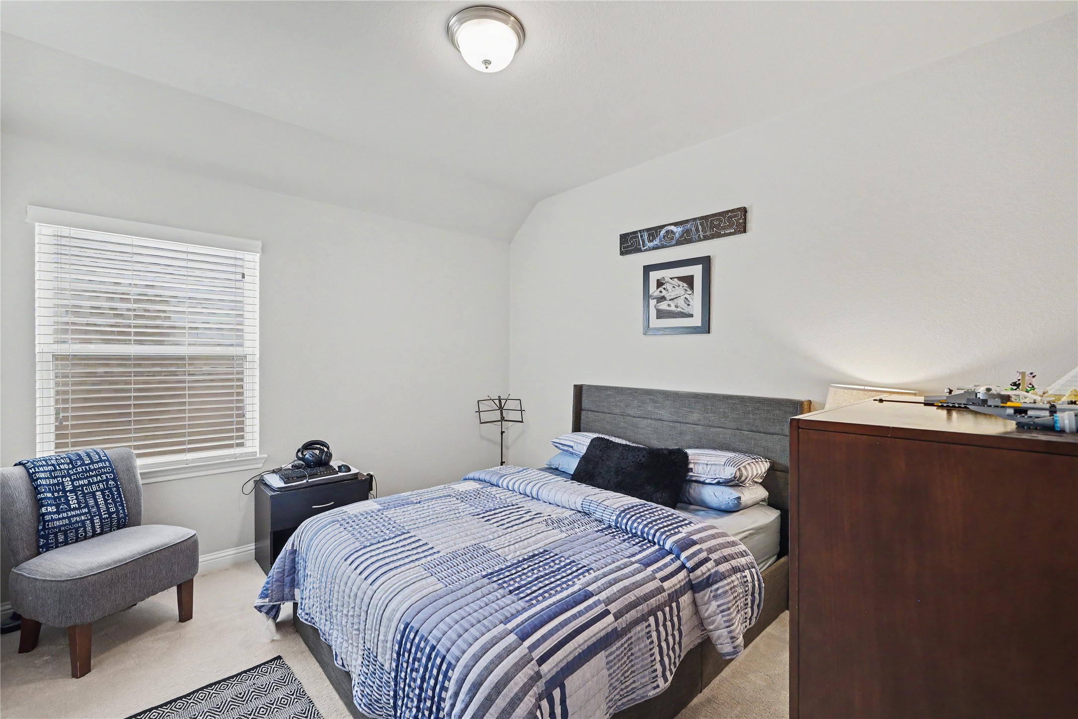 Secondary bedroom with ceiling fan, natural light, and flexible furniture arrangement.