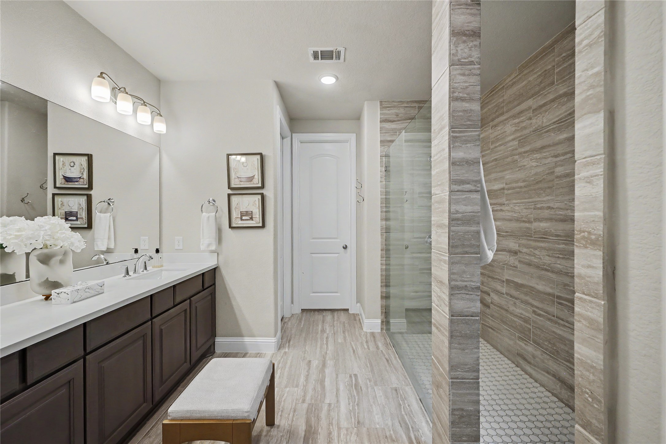 Primary bathroom with dual vanities, soaking tub, and separate walk-in shower.