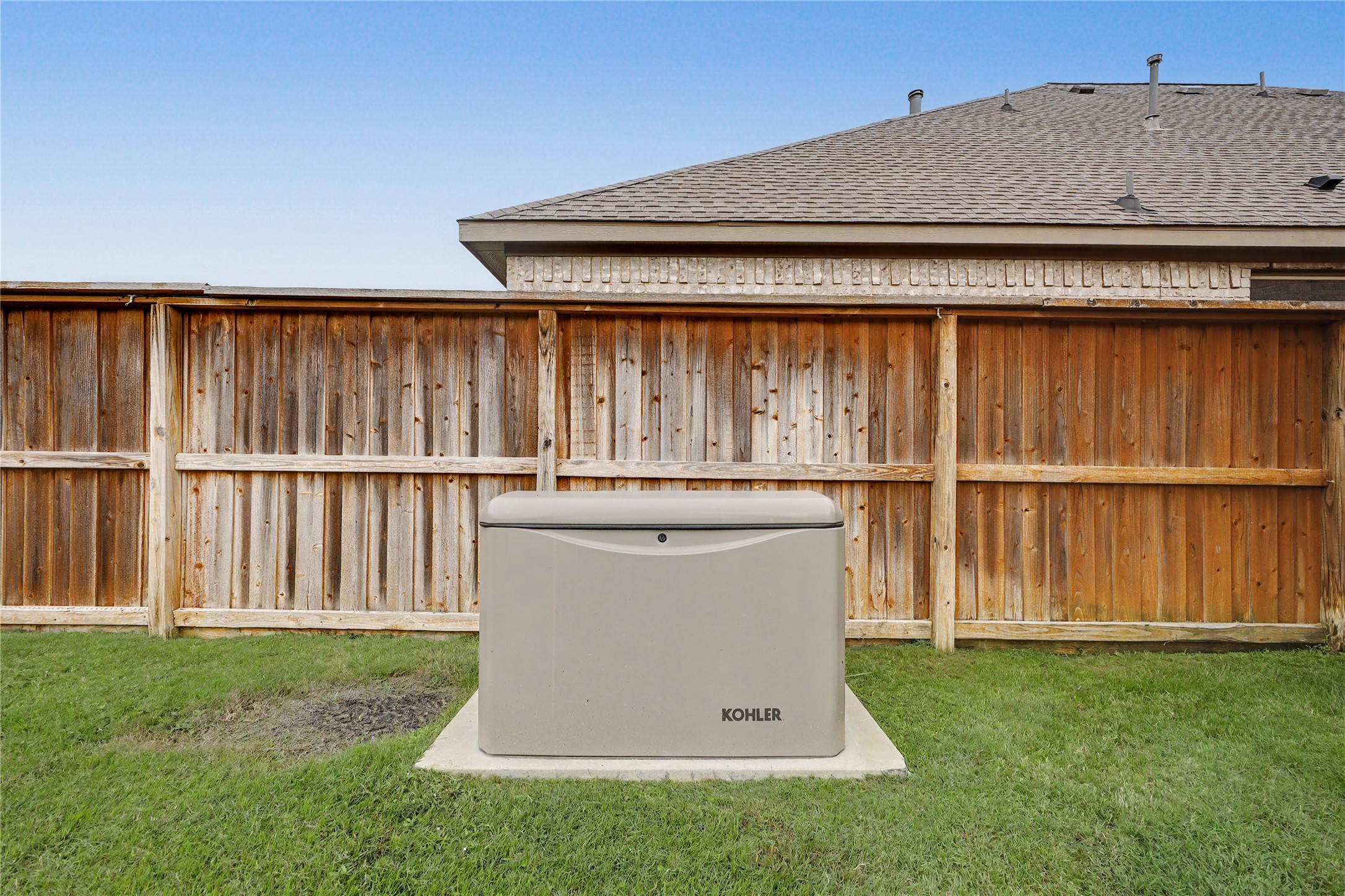 Fully fenced backyard with KOHLER generator.