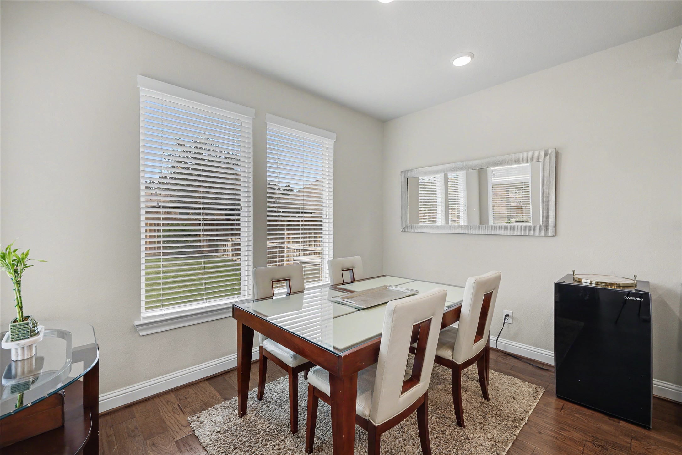 Breakfast area with backyard-facing windows and wood flooring.