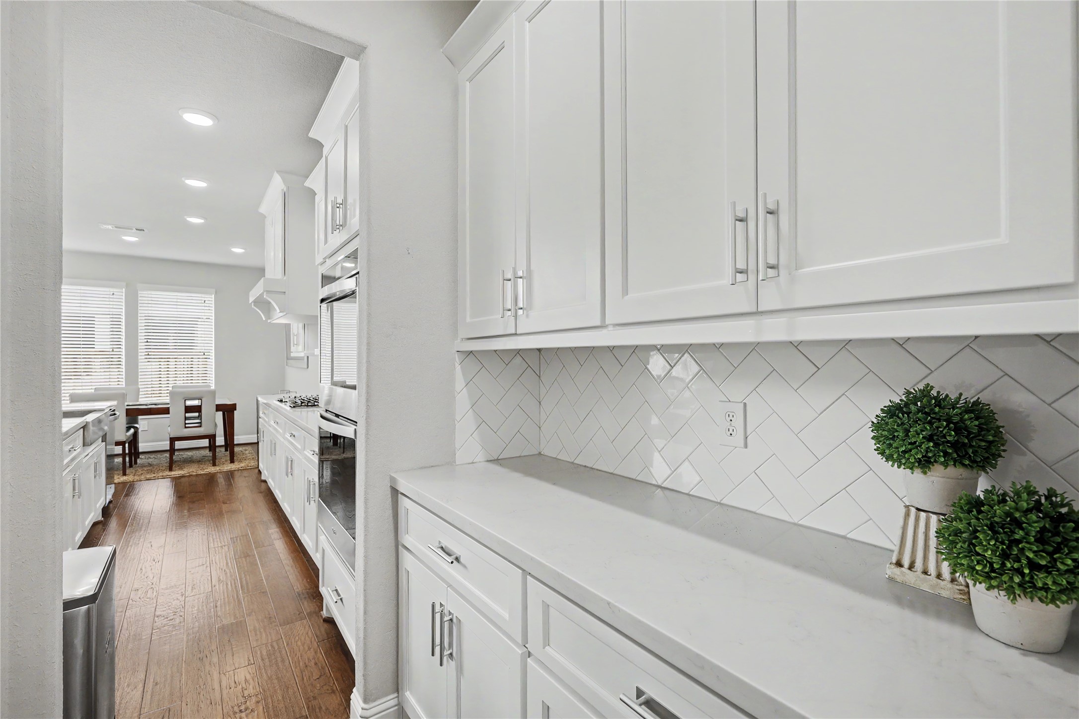 Butlers pantry connecting the formal dining room to the kitchen, offering additional cabinetry, counter space, and convenient access for entertaining.