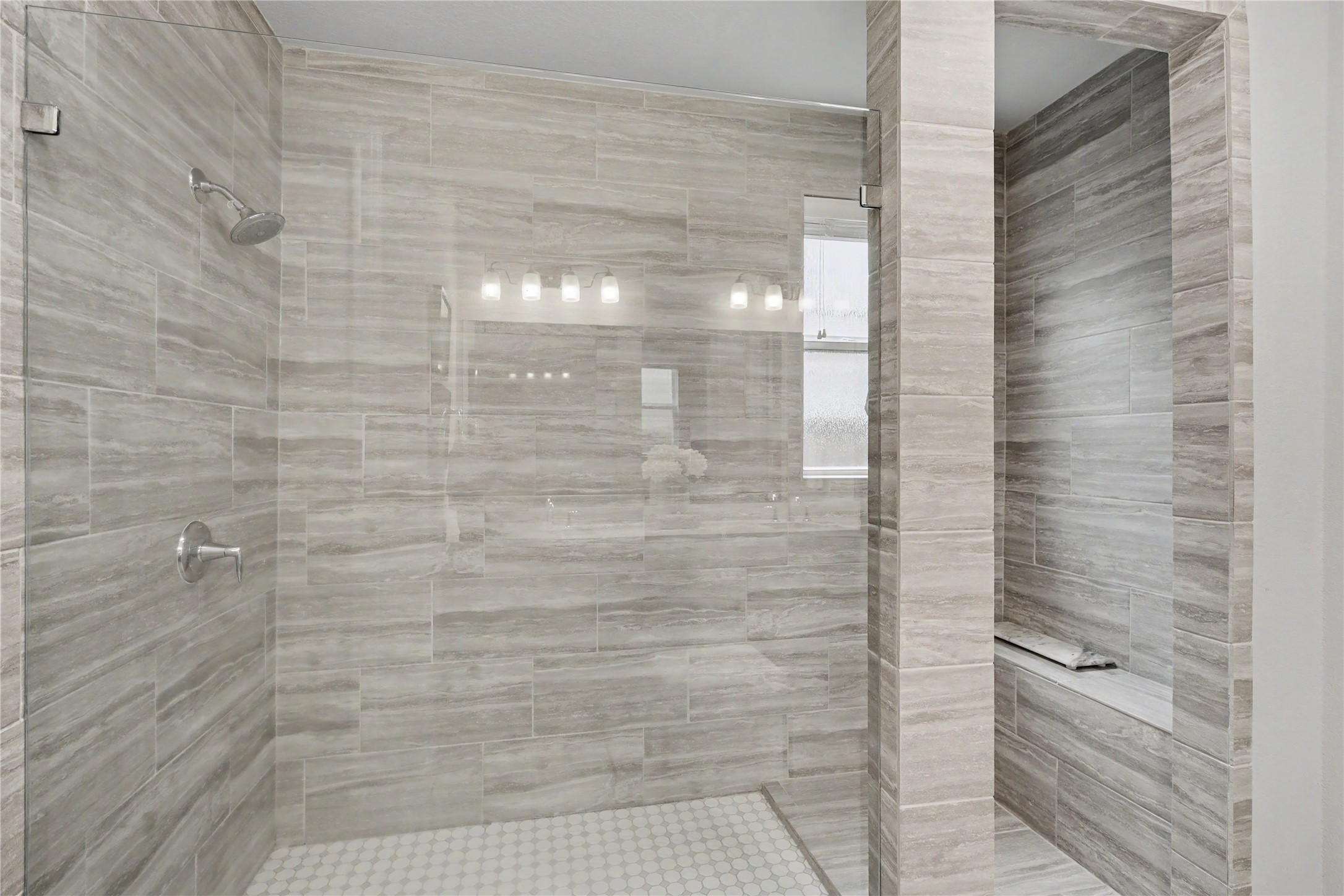 Primary bathroom featuring a spacious walk-in shower with tile surround and glass enclosure.