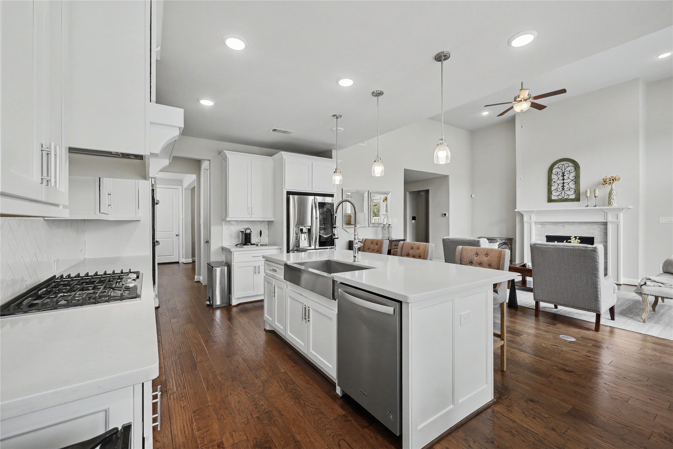 Open-concept kitchen and great room with wood flooring and abundant natural light.