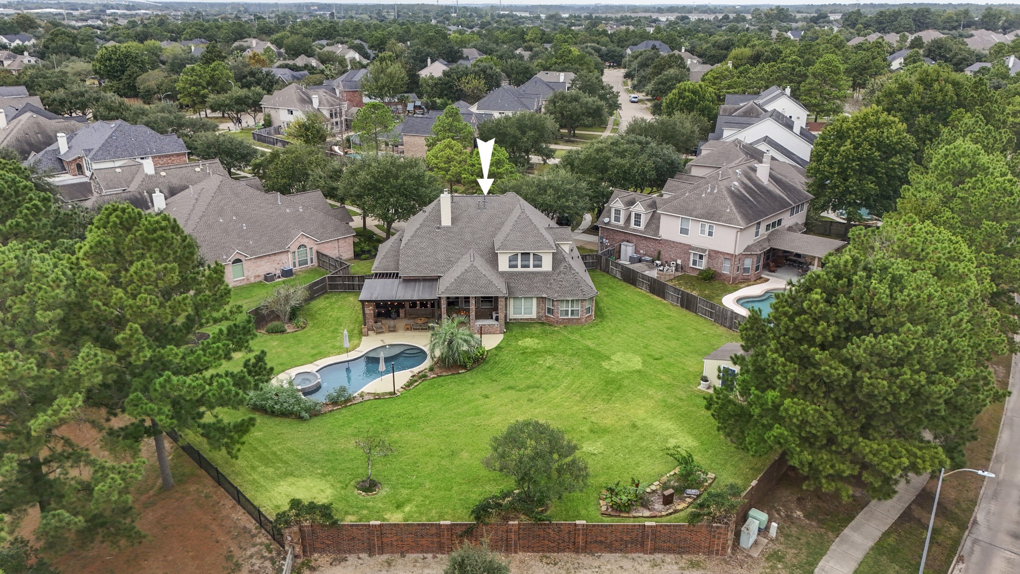 An aerial view showing one section of the fence line has a brick fence, whilst the golf course side is a wrought iron fence.