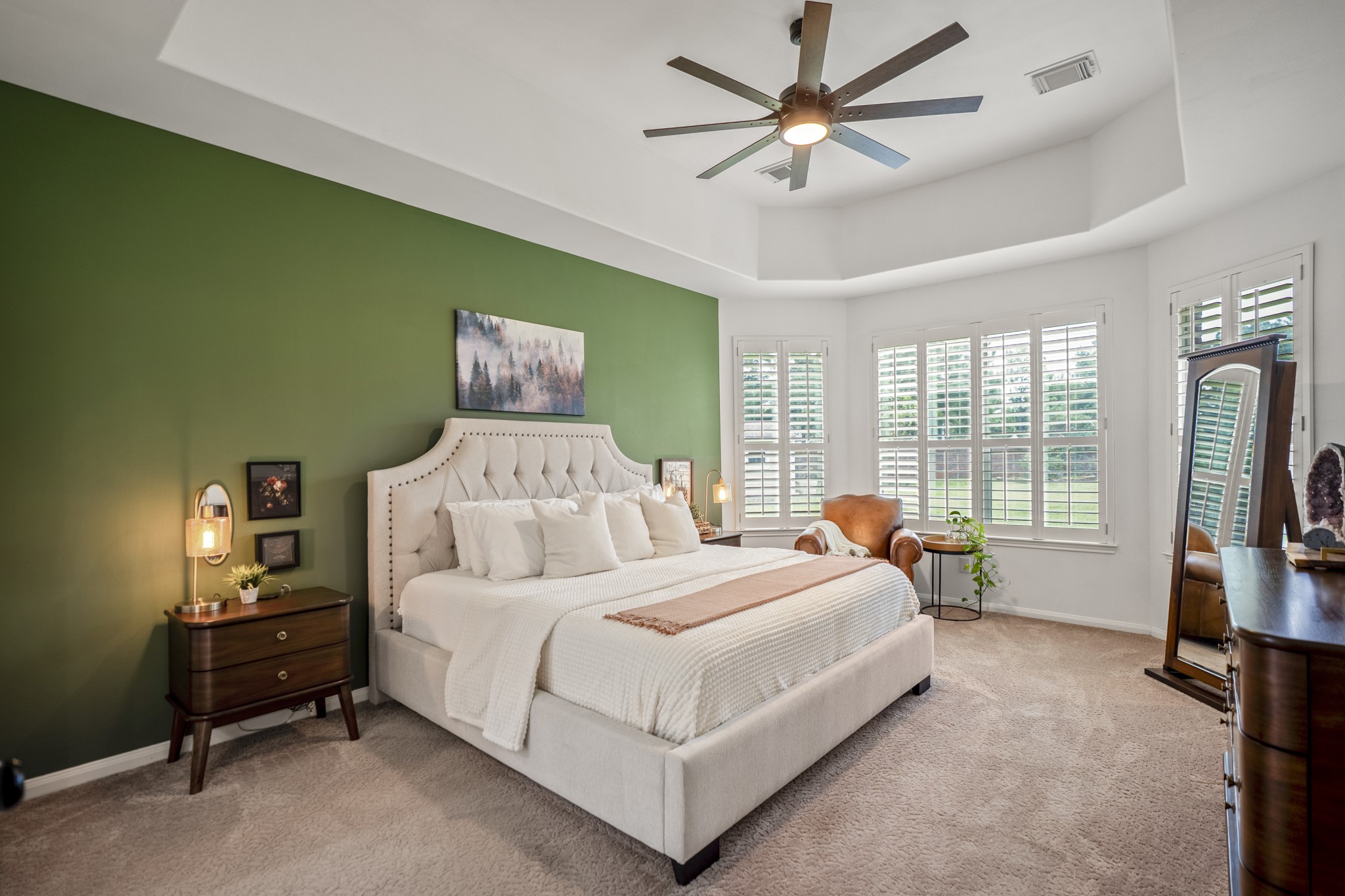 The primary suite has a large trey ceiling with large ceiling fan, a bay window with plantation shutters with wonderful views of the backyard.