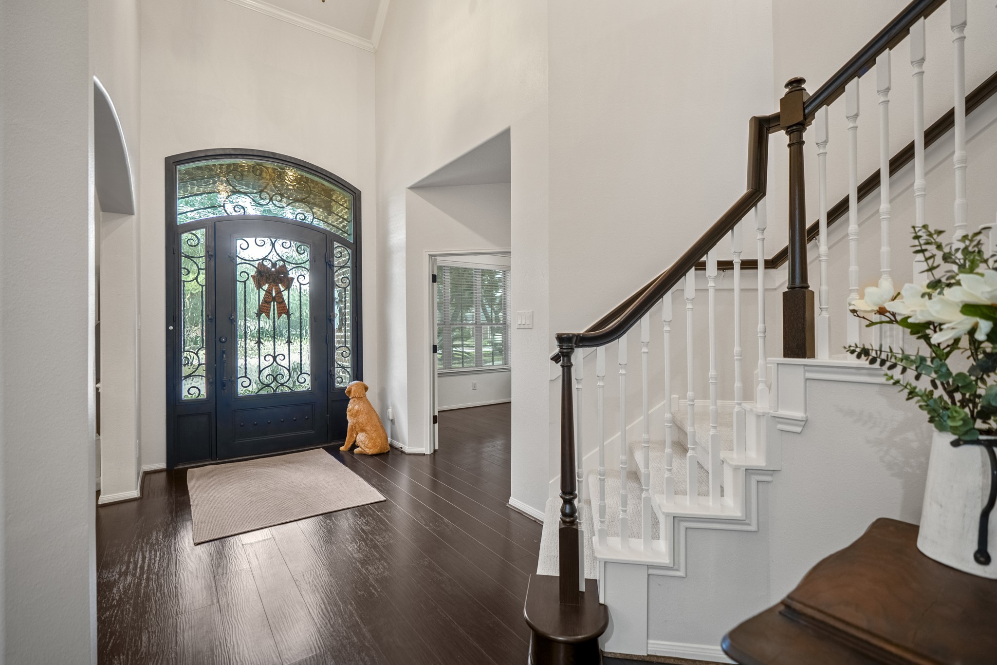 A breathtaking entrance that sets the standard for the entire home, with spectacular custom front door, featuring intricate leaded-glass detailing, and magnificent arched transom window that floods the foyer with natural light.