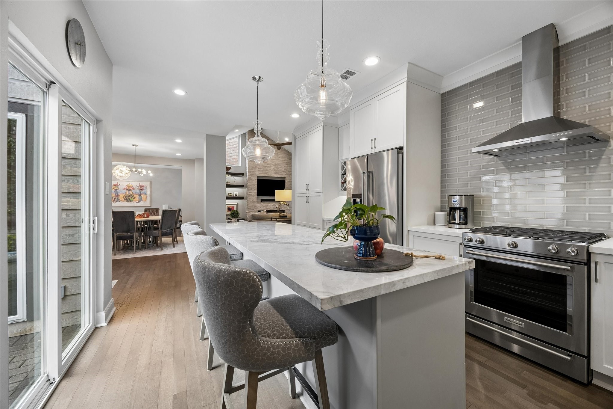 KITCHEN II: Gourmet kitchen features floor-to-ceiling cabinetry, a built-in wine rack, porcelain backsplash, undercabinet lighting,  designer pendant lighting and generous countertop space.