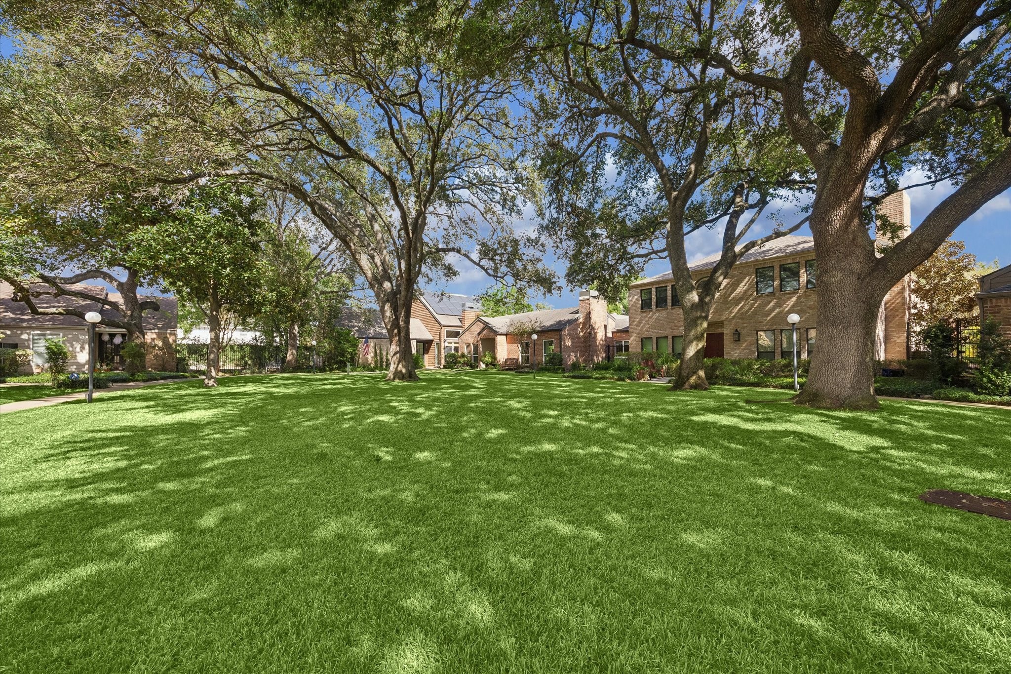 Beautifully maintained community green space features expansive lawns, mature shade trees and a peaceful park-like setting.