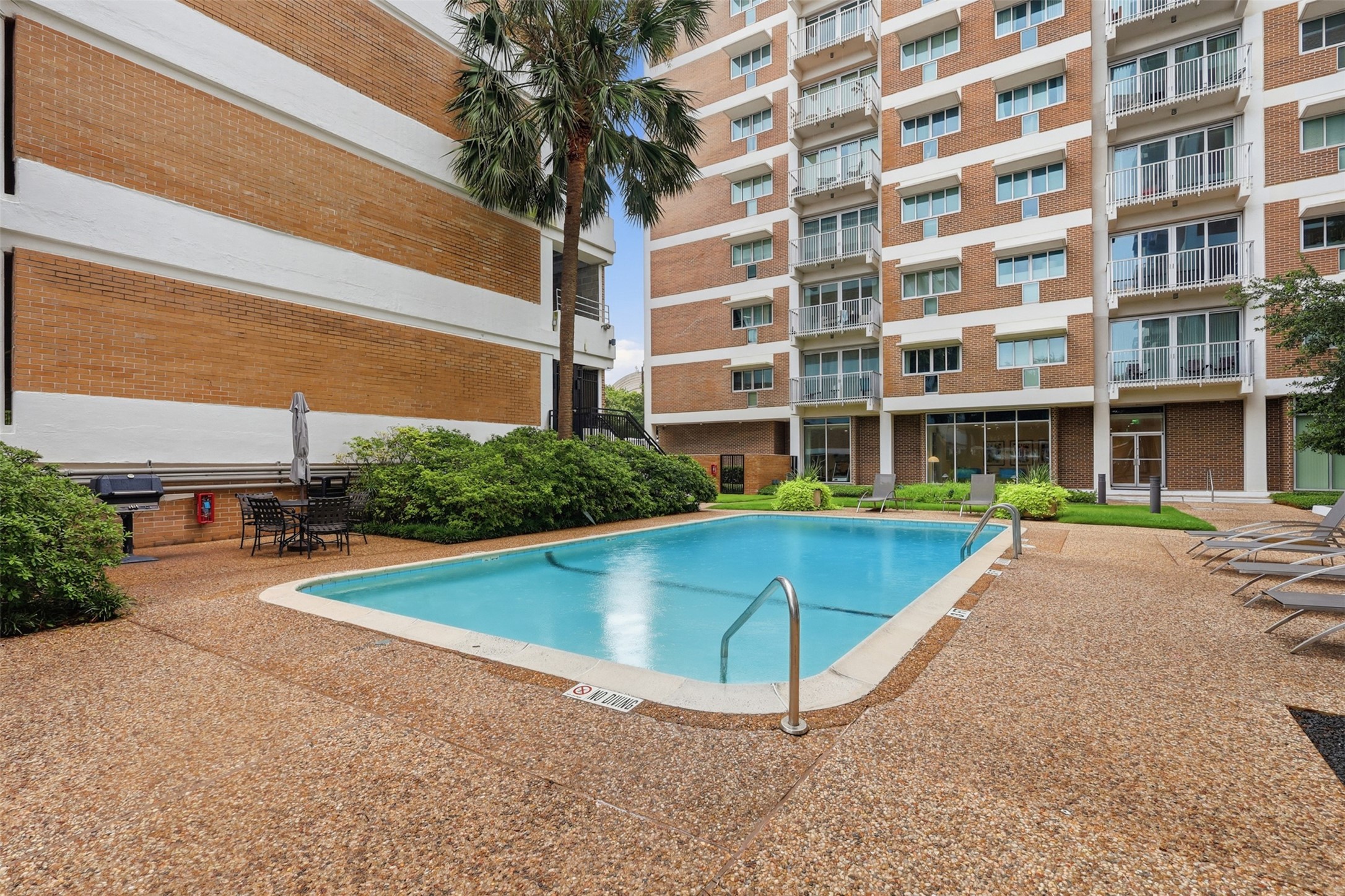 Community pool with several outdoor grilling areas.