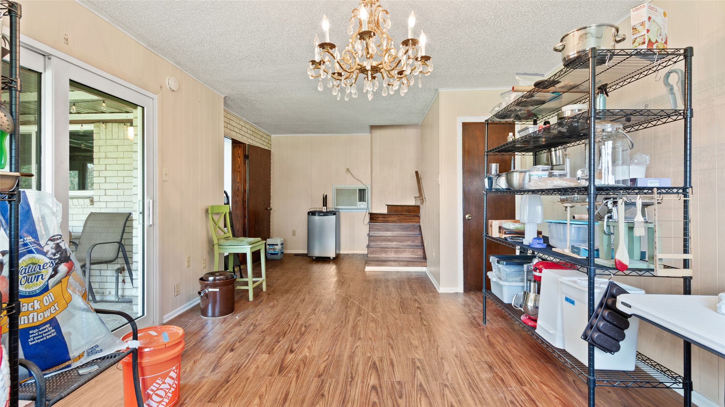 Alternate view of the formal dining area highlights the generous room dimensions, wood-look flooring, and direct access to the covered patio.