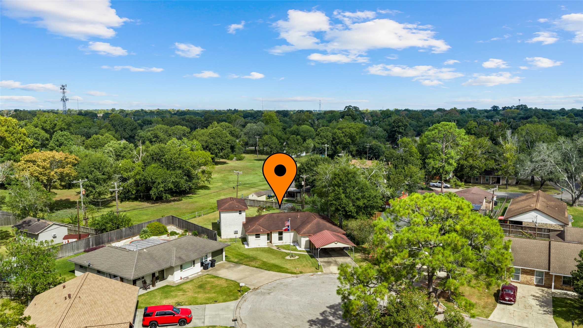 Aerial view highlights the homes cul-de-sac setting with a generous backyard and open green space beyond the property.