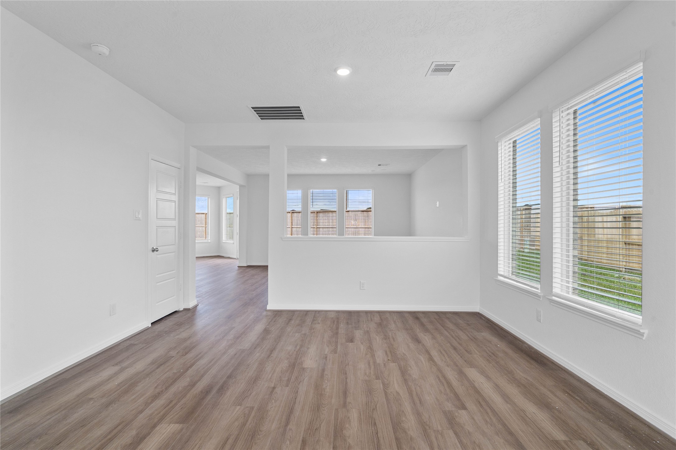 Create lasting memories with family and friends in this inviting dining room! It showcases high ceilings, recessed lighting, neutral paint, and stunning vinyl plank flooring.