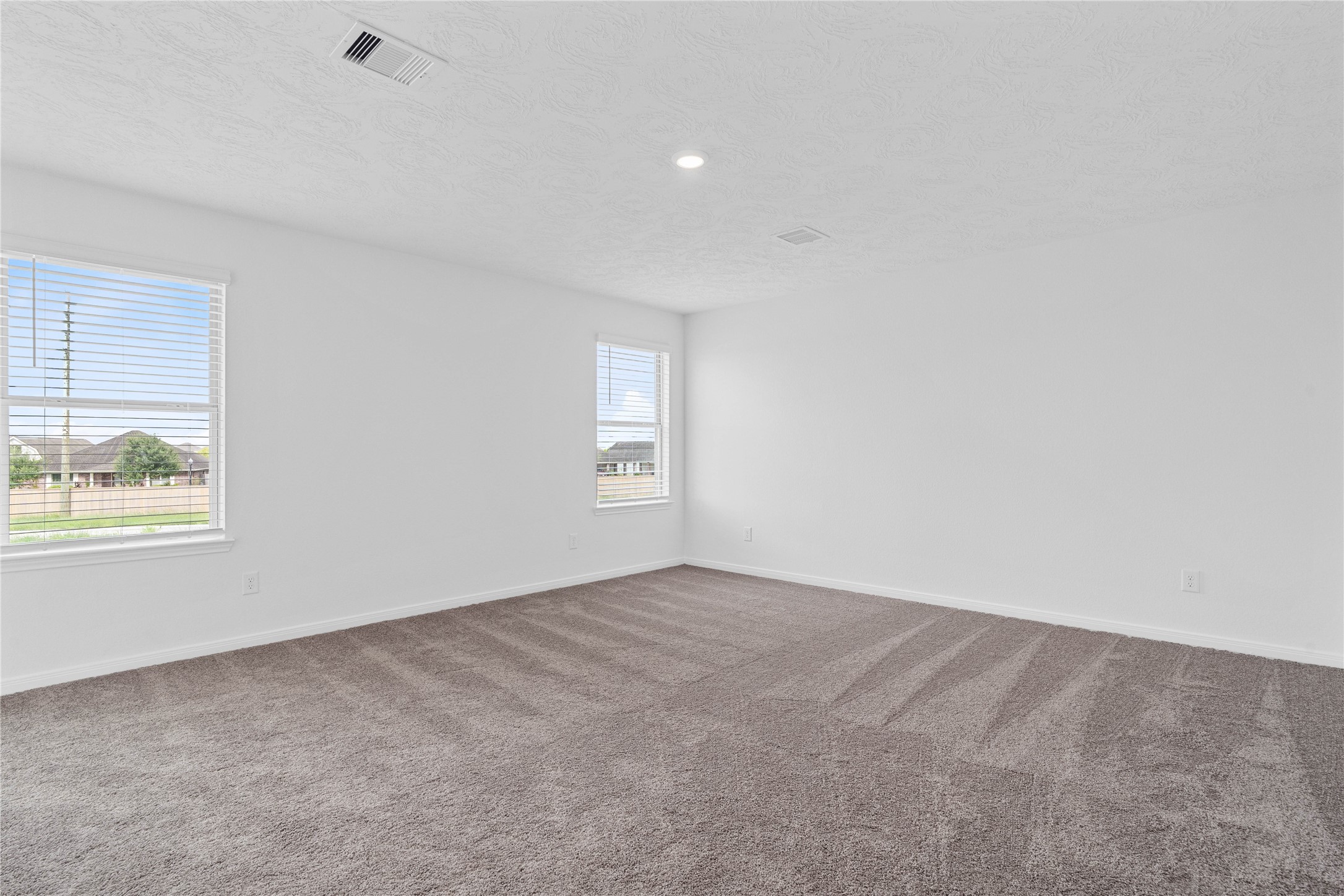 Relax and recharge in this stunning primary suite! This expansive room offers plush carpeting, neutral-toned walls, high ceilings, recessed lighting, large windows fitted with privacy blinds, and an added sitting areaperfect for unwinding after a long day.