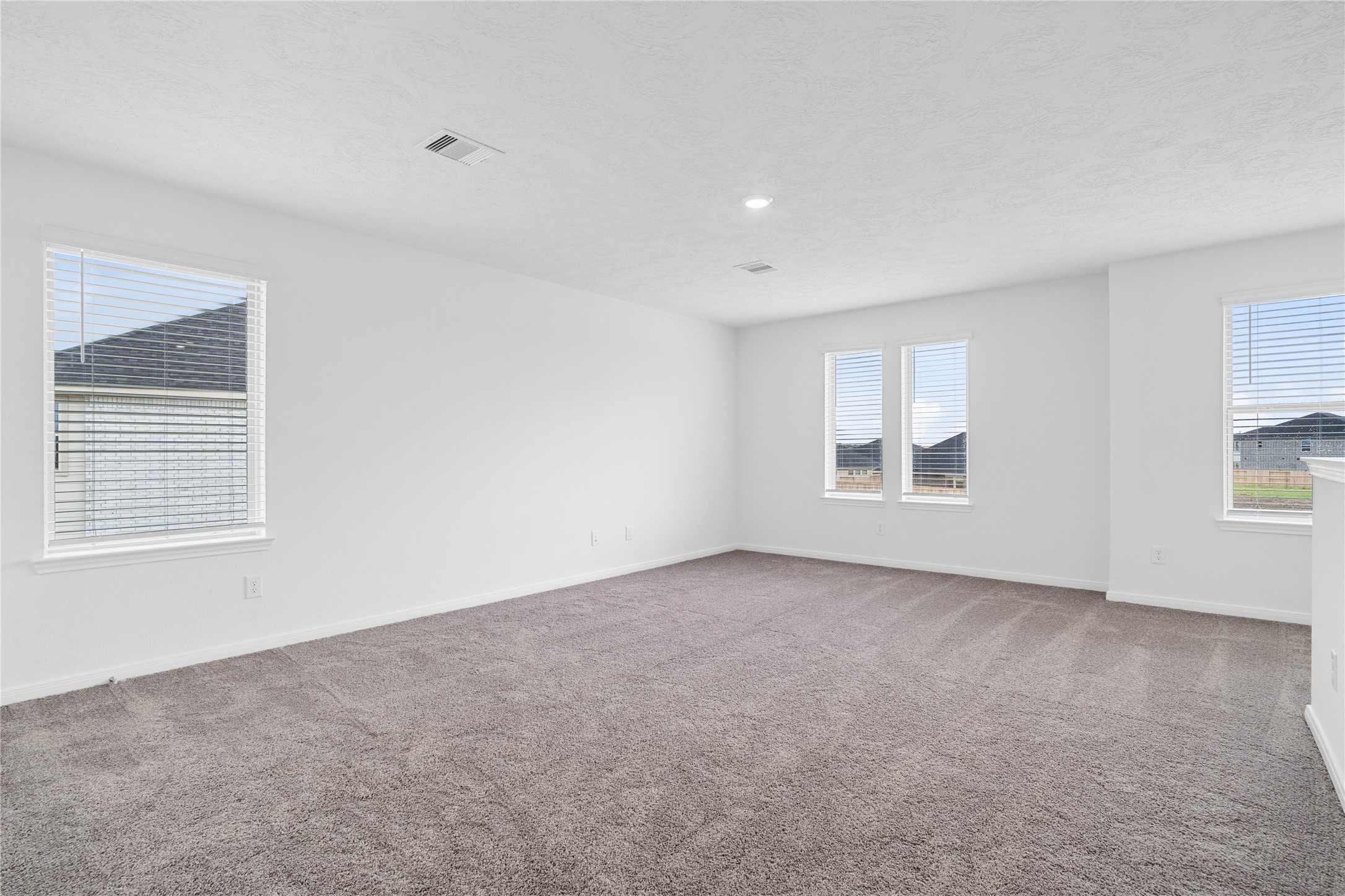 Head upstairs and enjoy the Loftan additional living area perfect for a game room, media space, or a peaceful retreat. Featuring plush carpet flooring, neutral paint, high ceilings, recessed lighting, and windows with blinds.