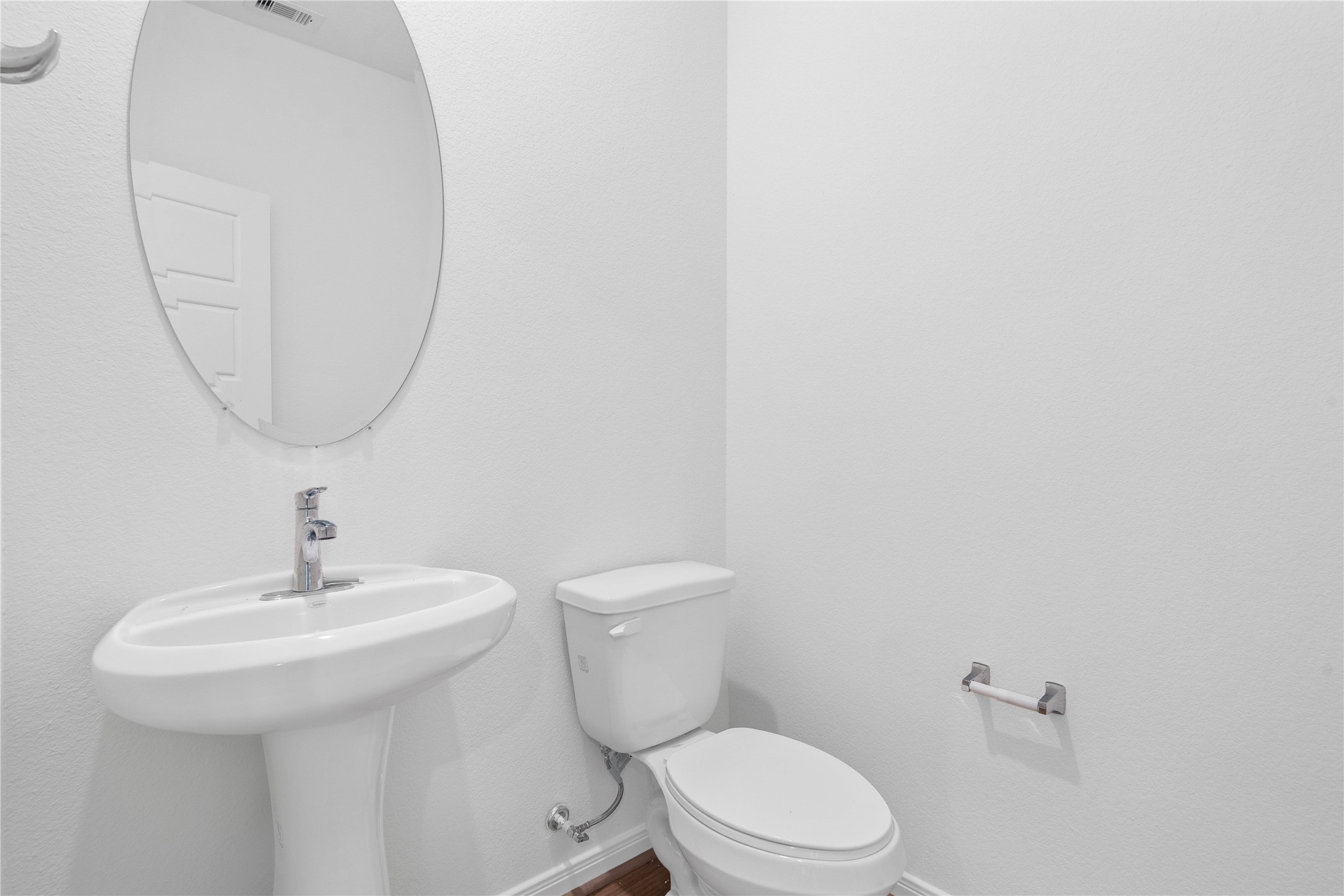 Perfectly situated on the main level for guests and residents, this charming powder room features a pedestal sink, mirror, and toilet.