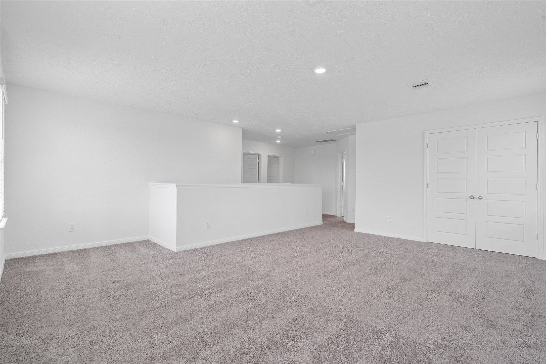 Another perspective of the Loft, showcasing the staircase, linen closet, and hallway leading to the secondary bedrooms.