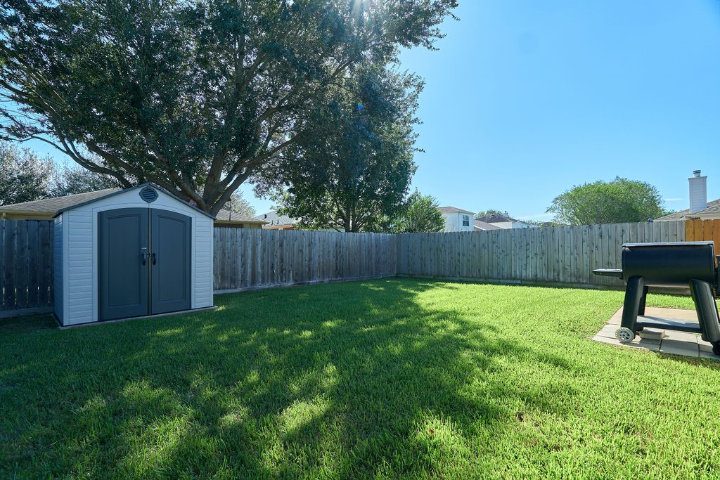 Room to breathe, play, and unwind! A generous grassy backyard framed by mature trees and open skies.