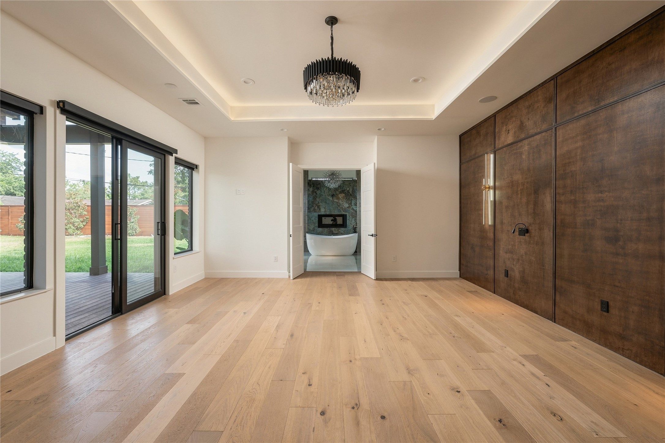 Primary Bedroom with Custom Wood Accents, Lighting, and Backyard Access