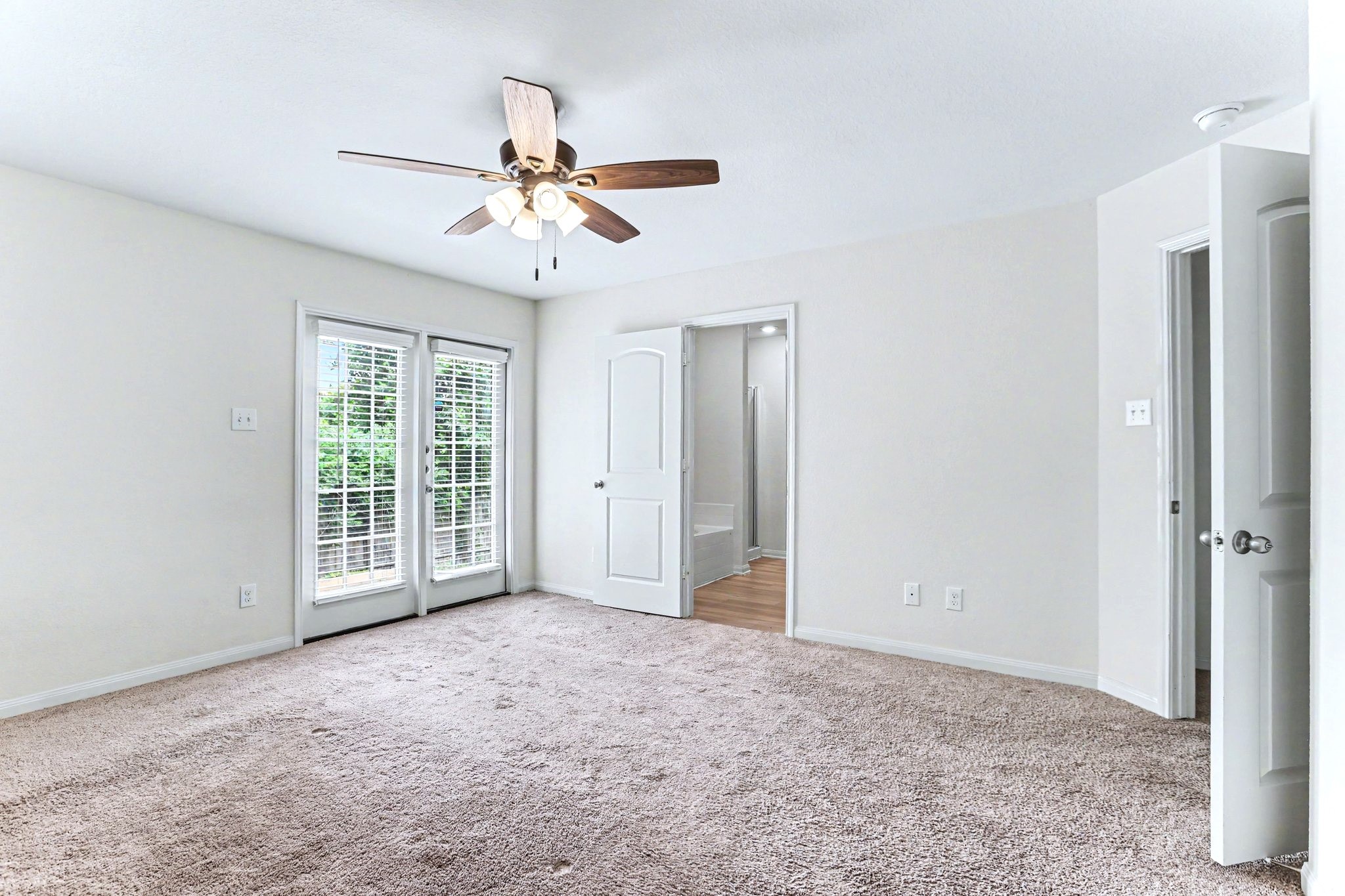 The primary bedroom has French doors going out to the back yard.