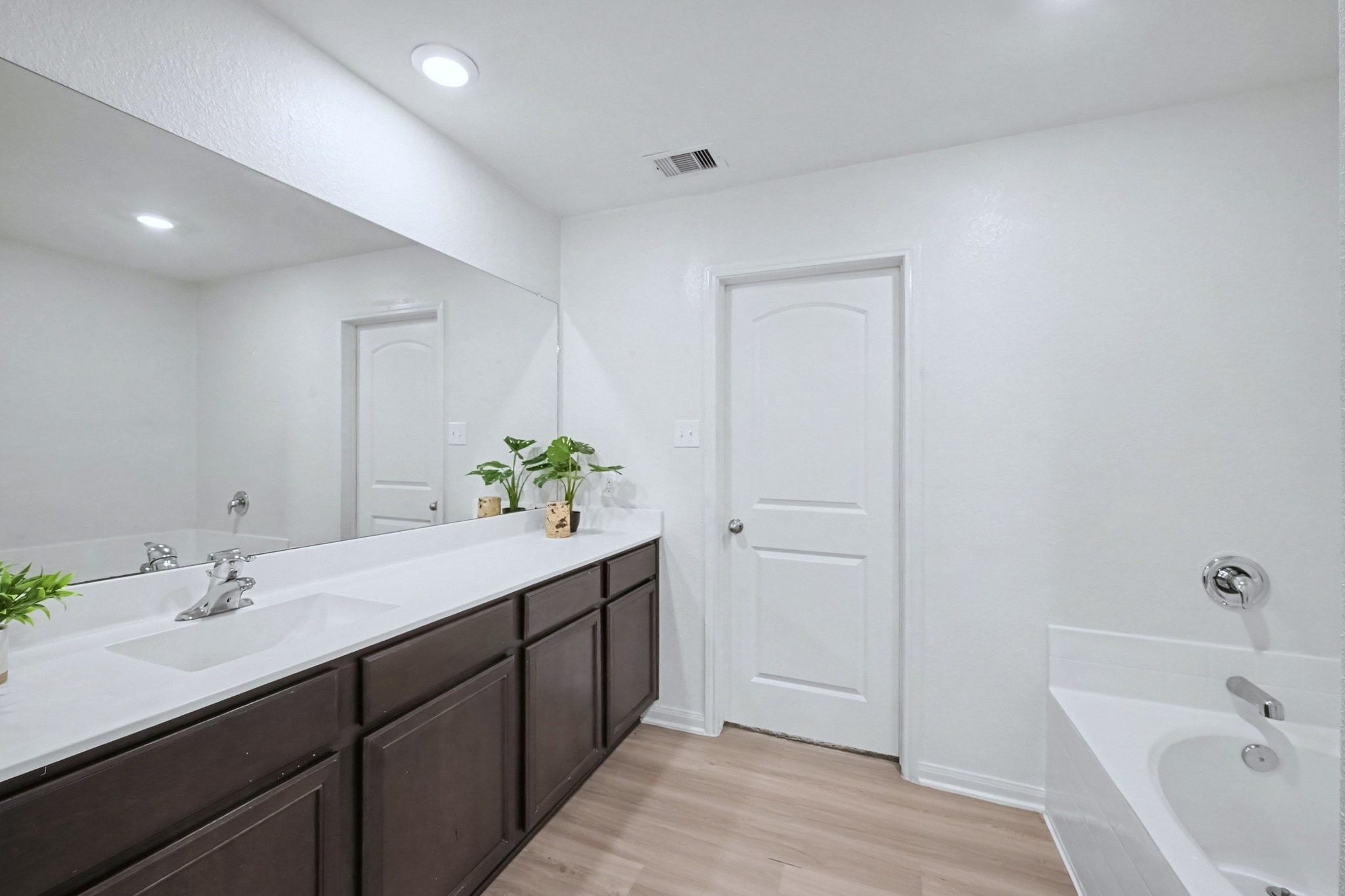 Primary bathroom showing the separate tub and door leading to the bedroom