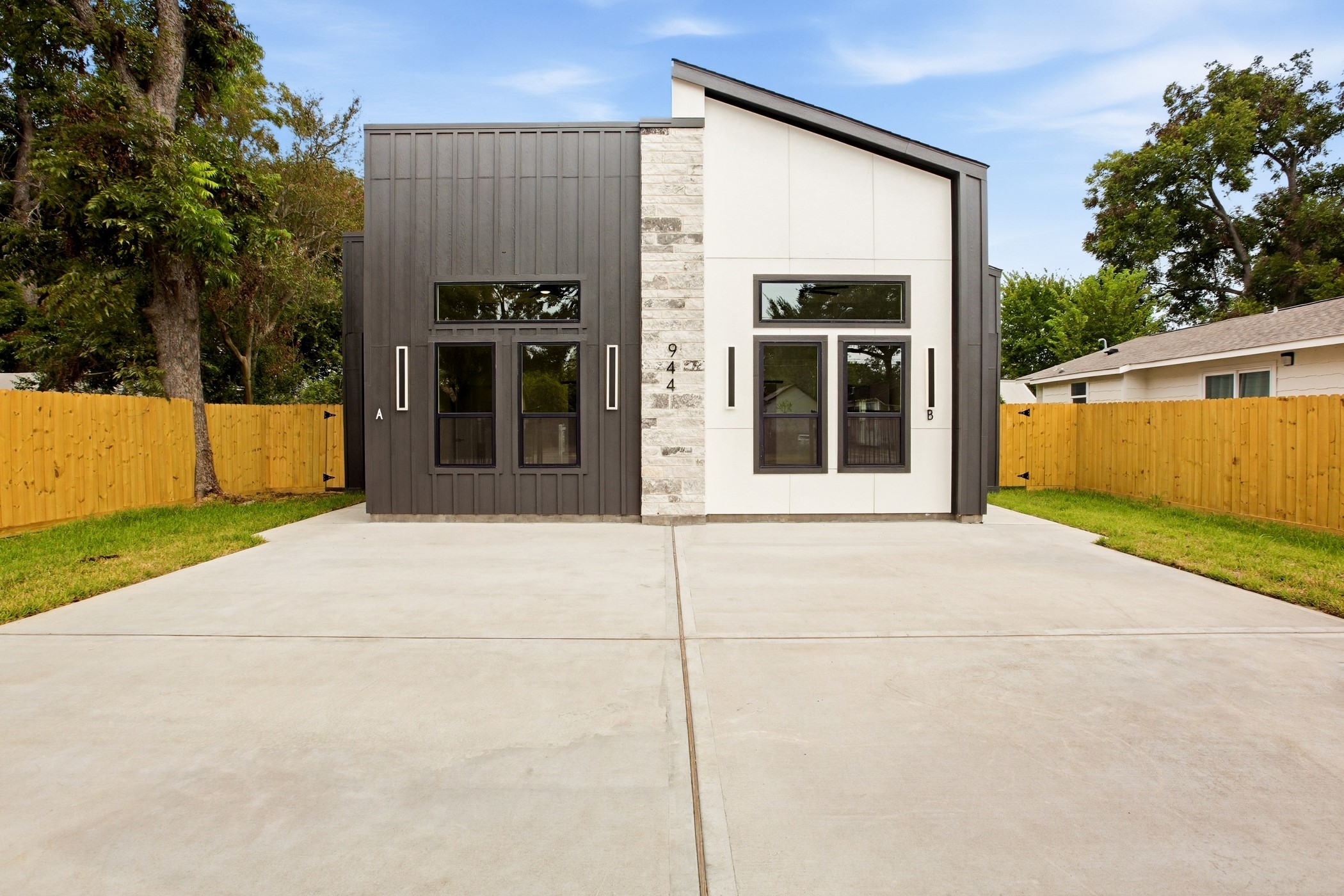 Contemporary faade framed by a spacious driveway and private yard.