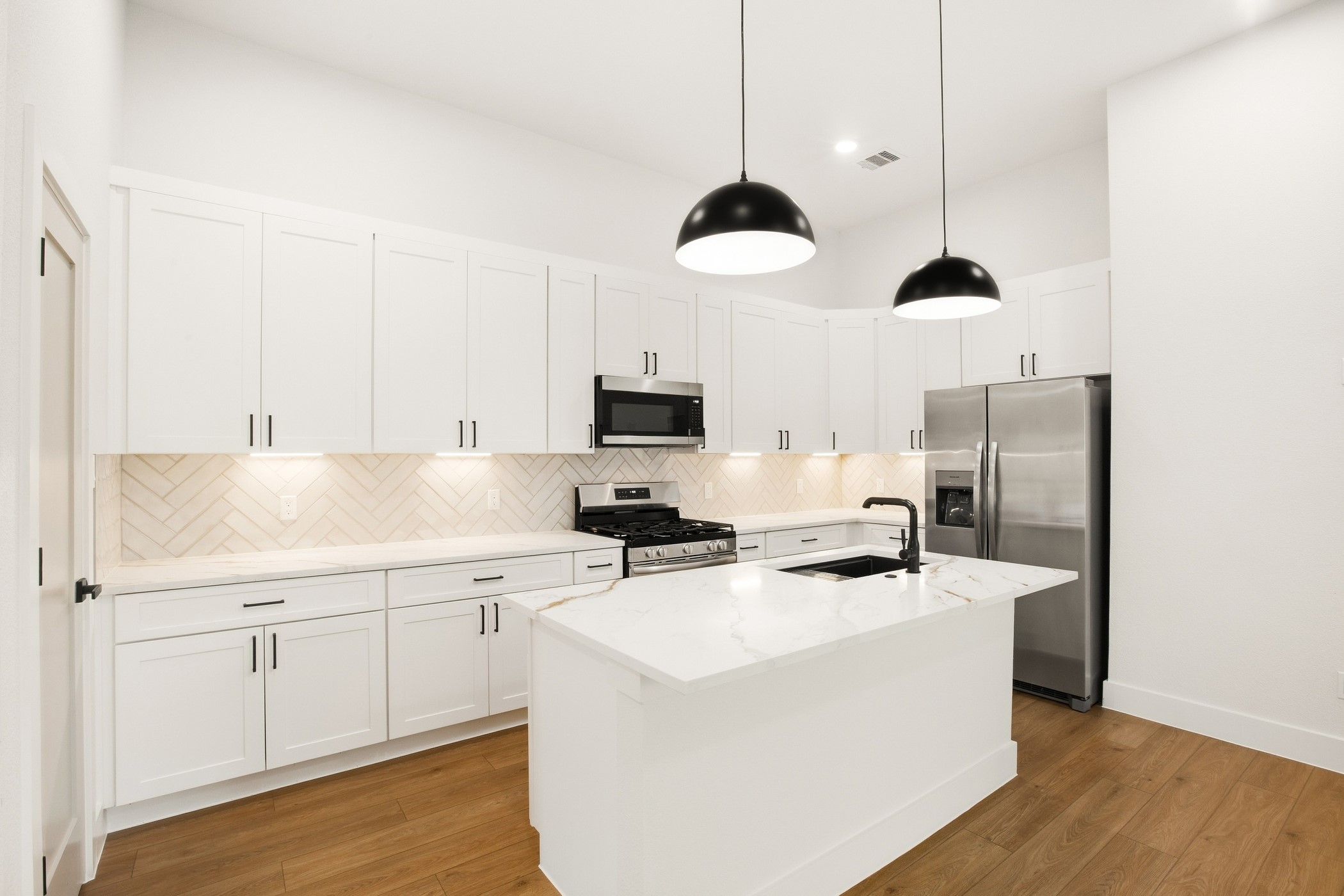 Modern kitchen featuring a large island and polished finishes.