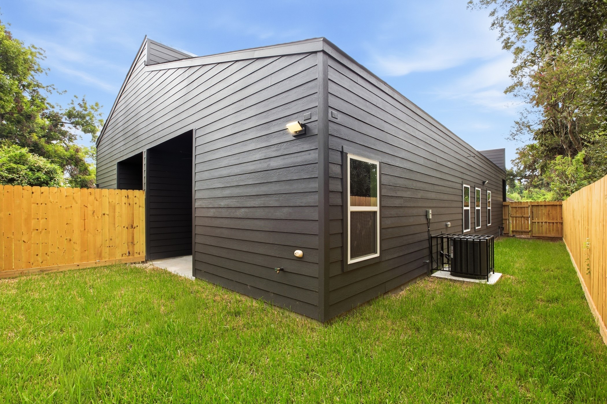 Modern rear elevation surrounded by a spacious, fully fenced yard.