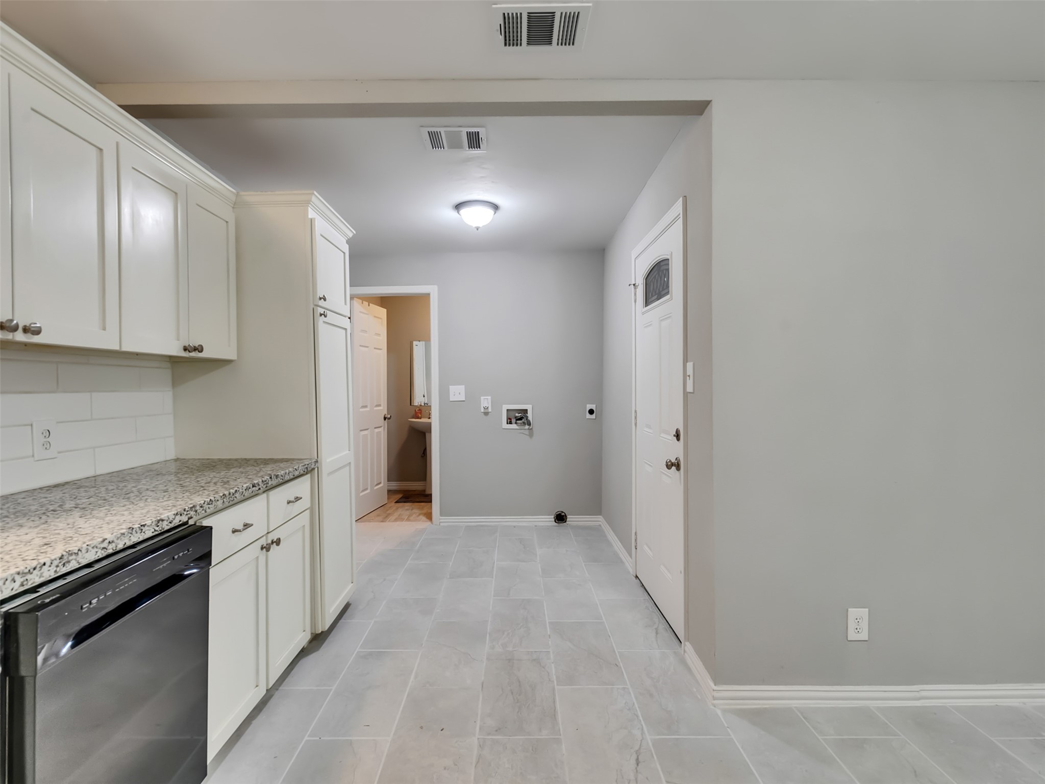 Kitchen looking at back door, washer/dryer connections and secondary bathroom.