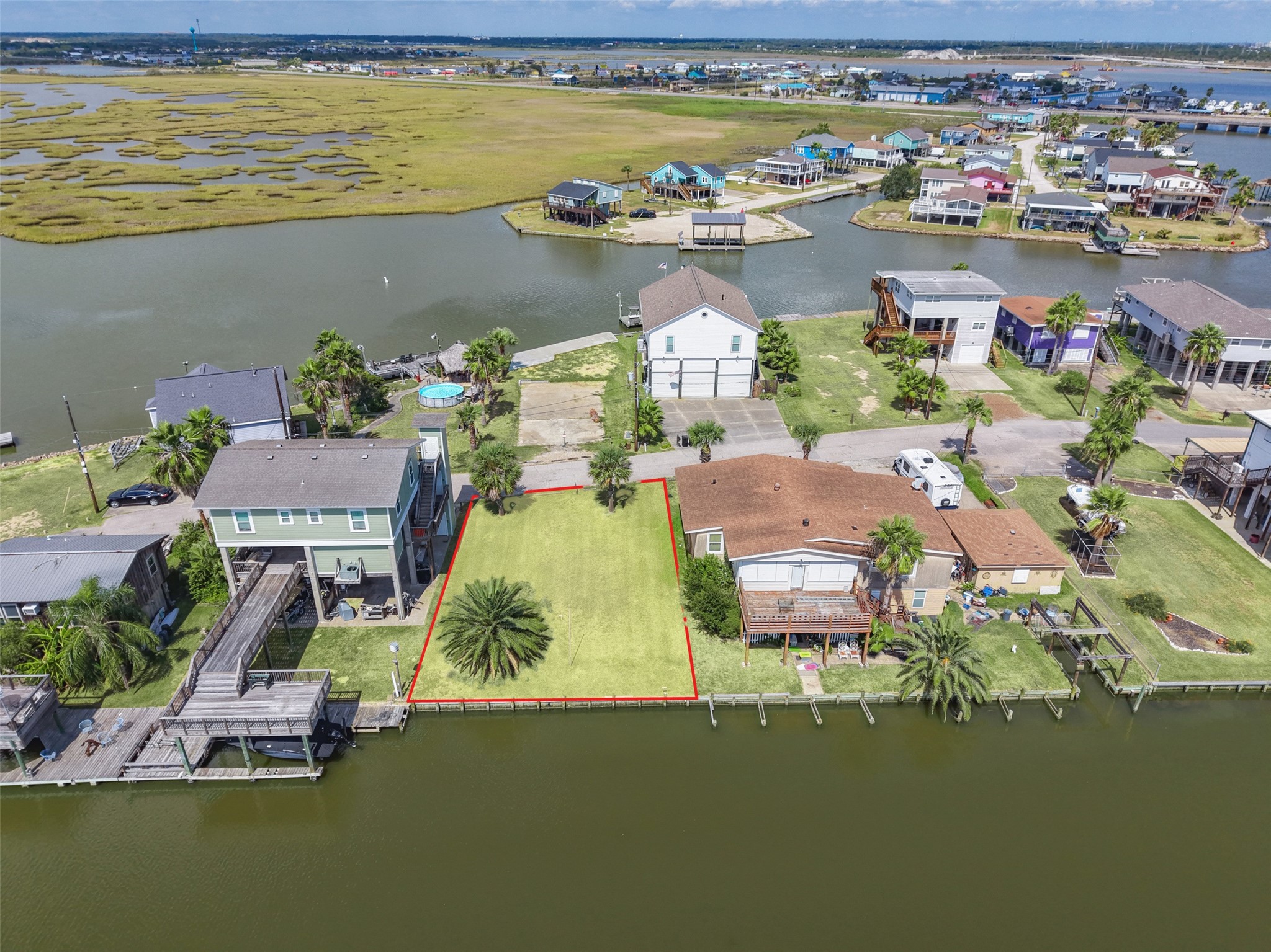 From out over the canal looking back at the lot. Wood bulkhead across the back, a home on each side, and the water right at the back door of your future vacation home!