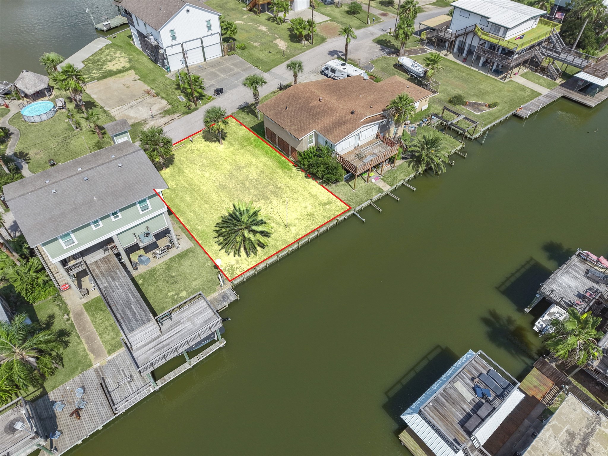 Angled overhead with the lot centered between its neighbors. Both homes beside it are recent builds. No HOA!