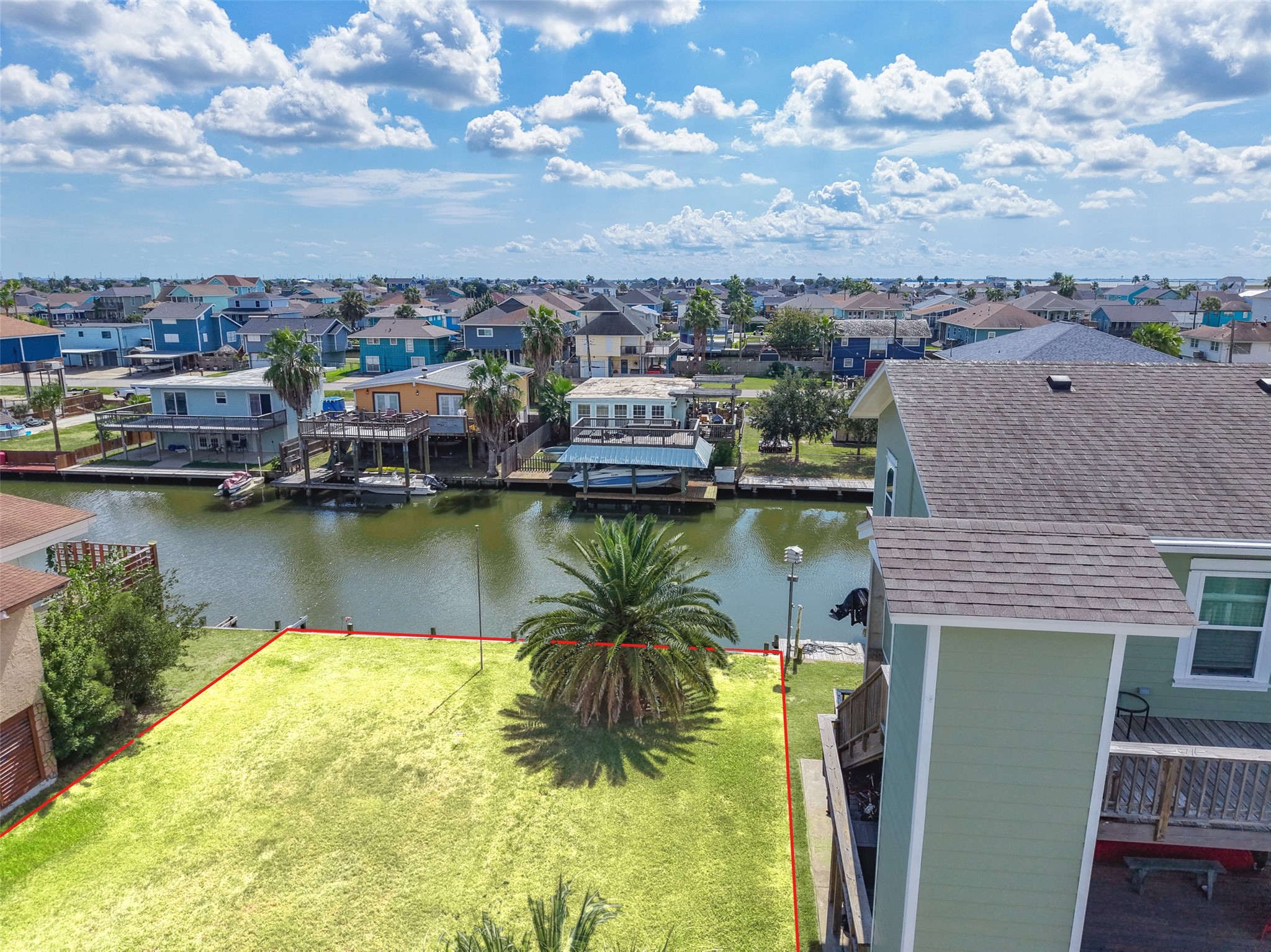 Low over the water. The Canary Island date palm and the grass come together here, and you can see how close the canal is to where a back deck could sit.