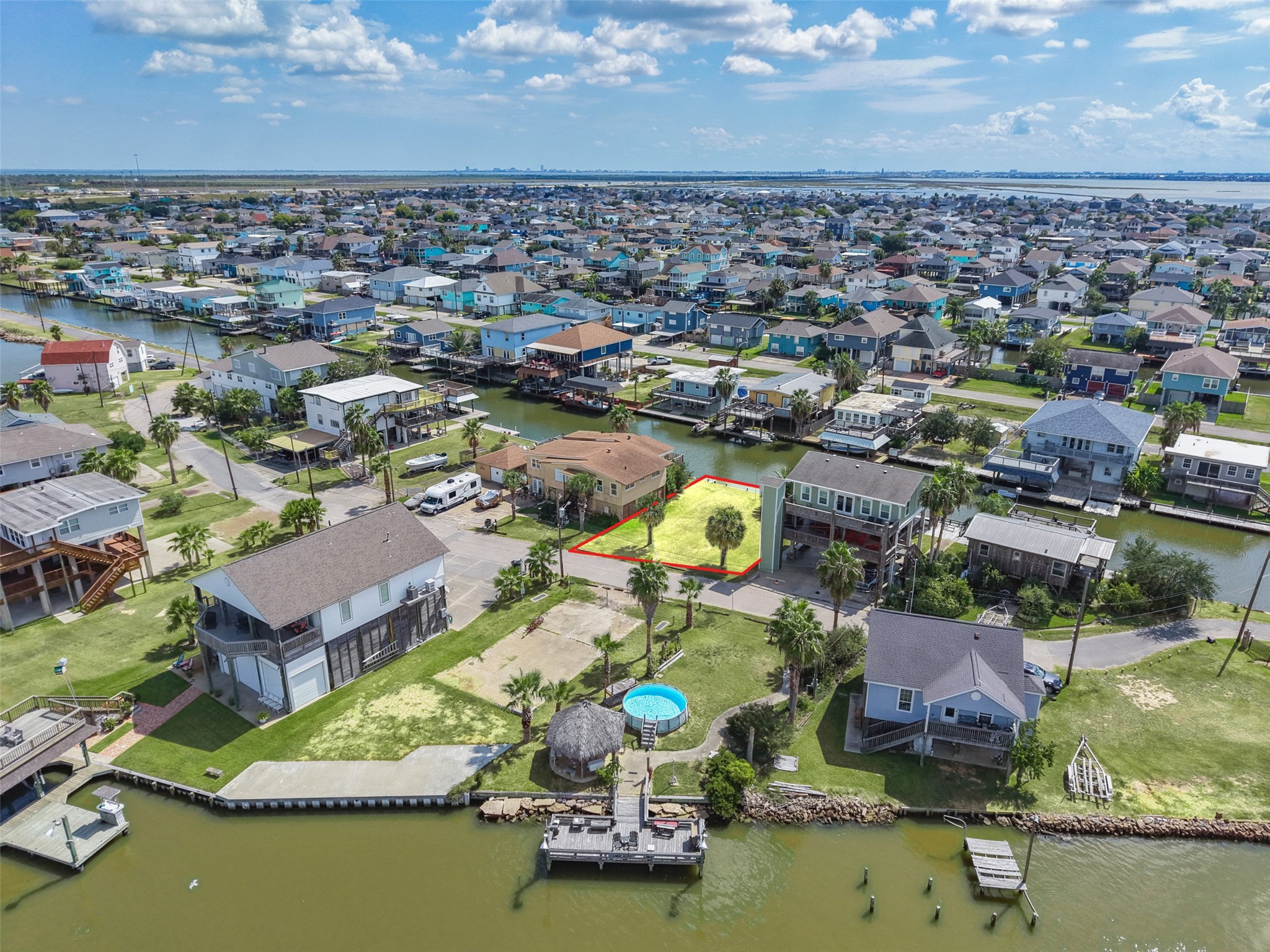 One more wide aerial: canals, rooftops and the bay beyond. Galveston Island State Park is about 9.0 miles away for beach days, and Moody Gardens is about 6.9.