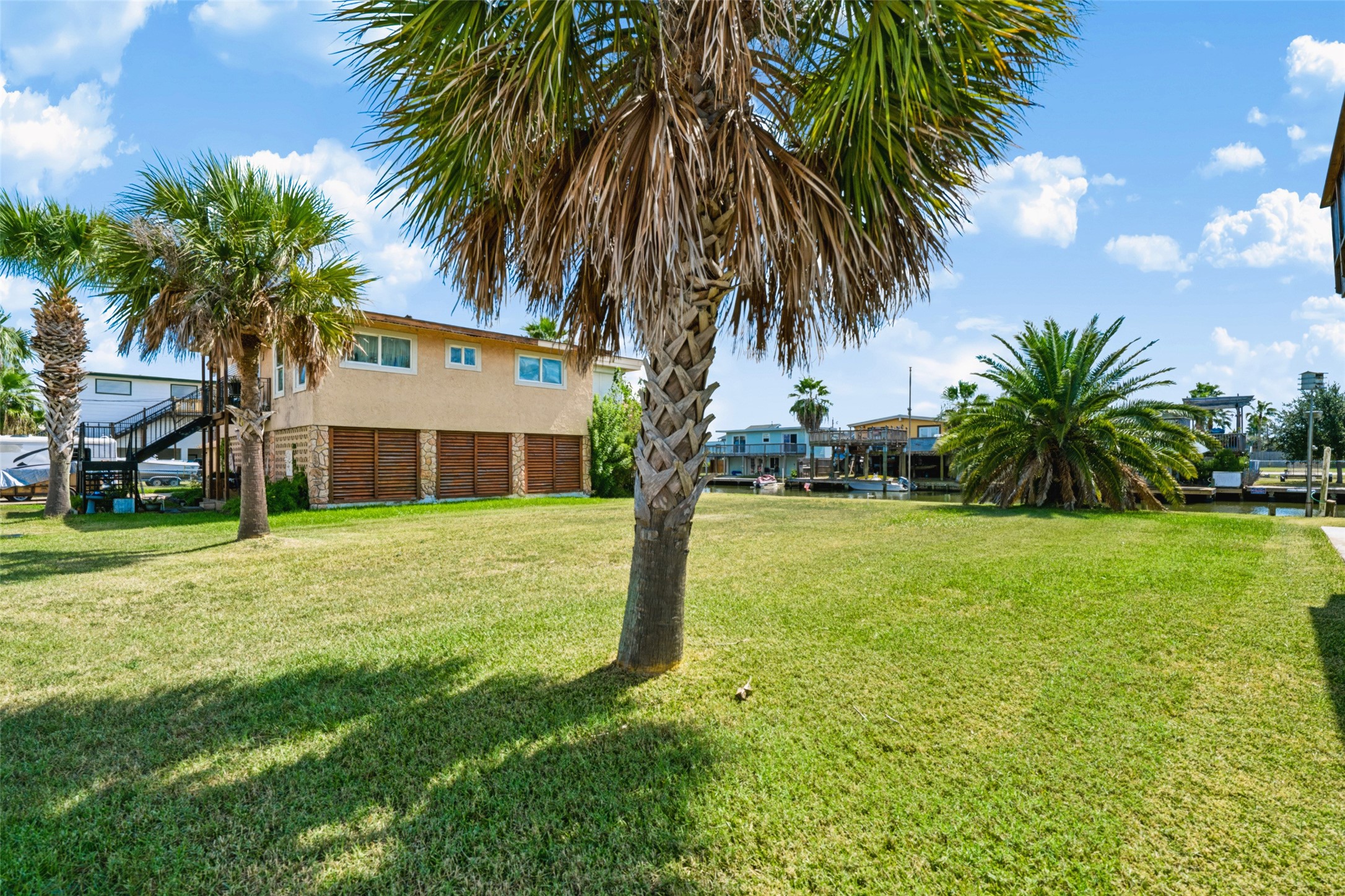 On the ground now! Two tall Sabal palms stand at the front of the lot and a full Canary Island date palm anchors the back, a nice head start on landscaping. The rest is cleared grass all the way to the water. Taxes on the lot were $1,419 in 2026.