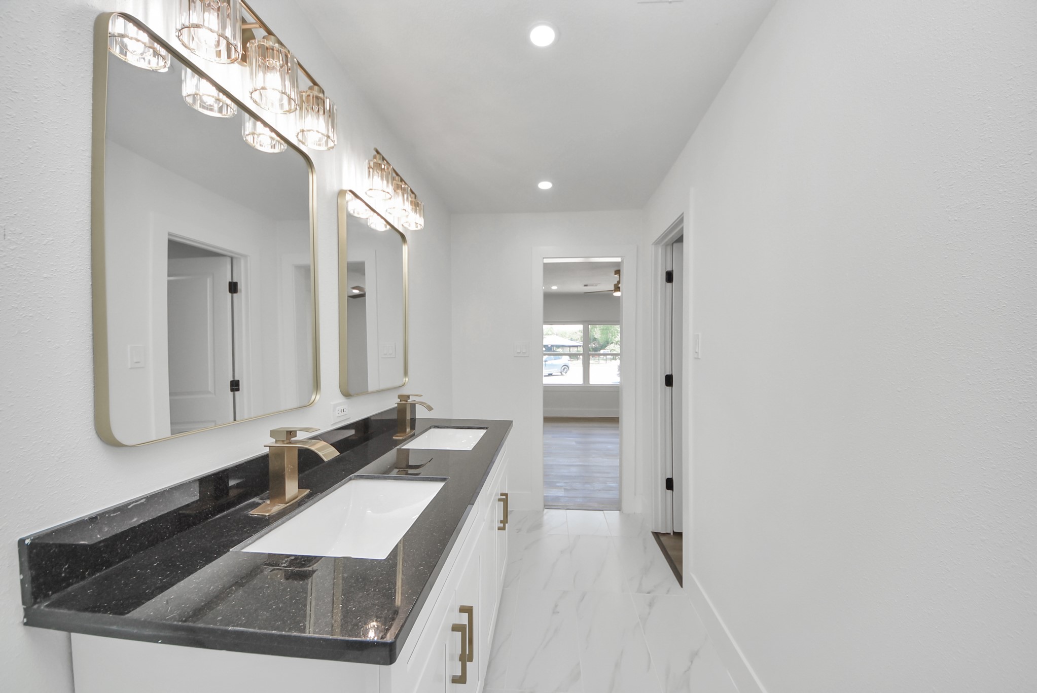 Elegant bathroom featuring a sleek double vanity with modern fixtures, chic lighting, and a spacious layout that flows into the main living area.