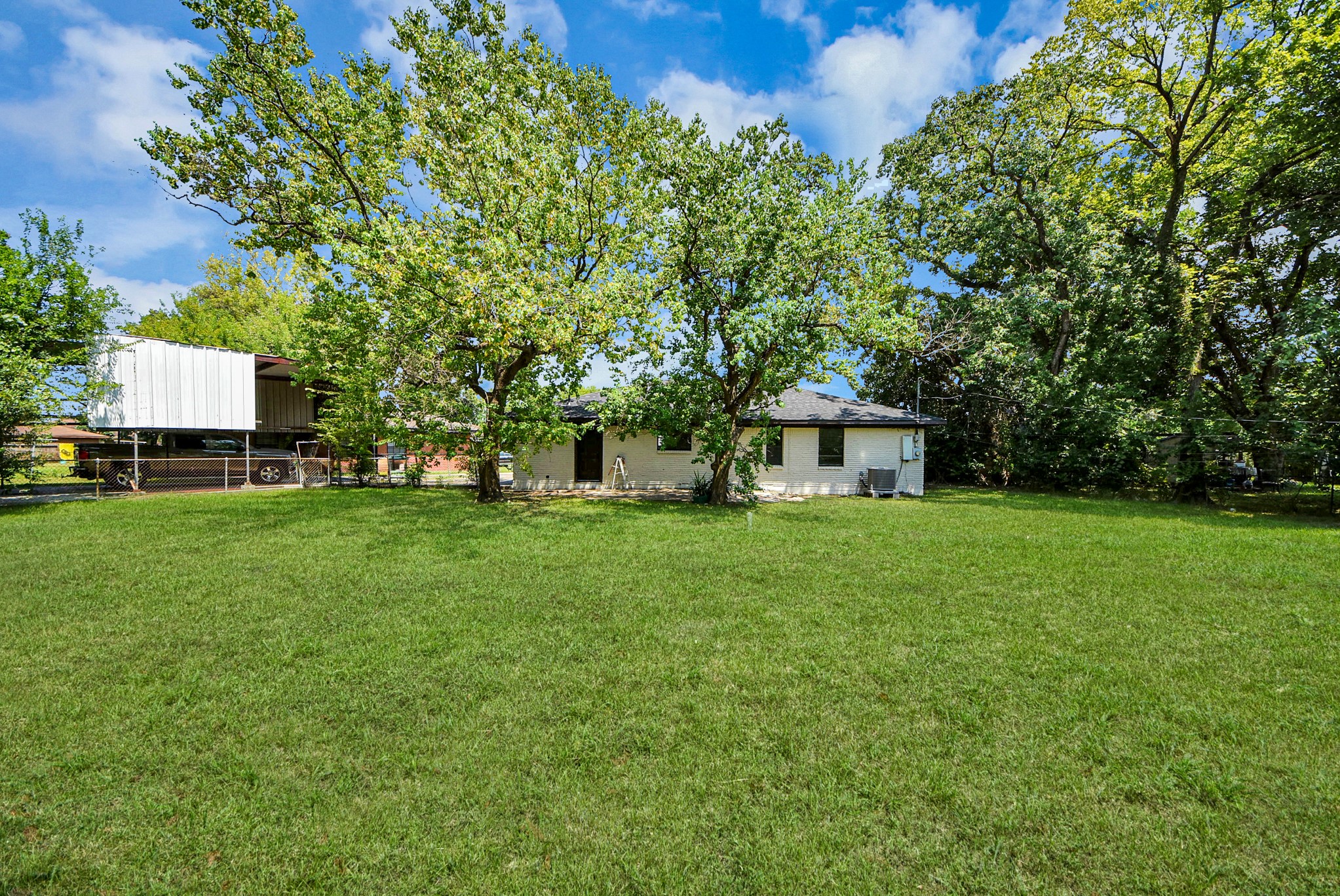 Expansive, lush green lawn with mature trees provides a serene, private setting for this charming home.
