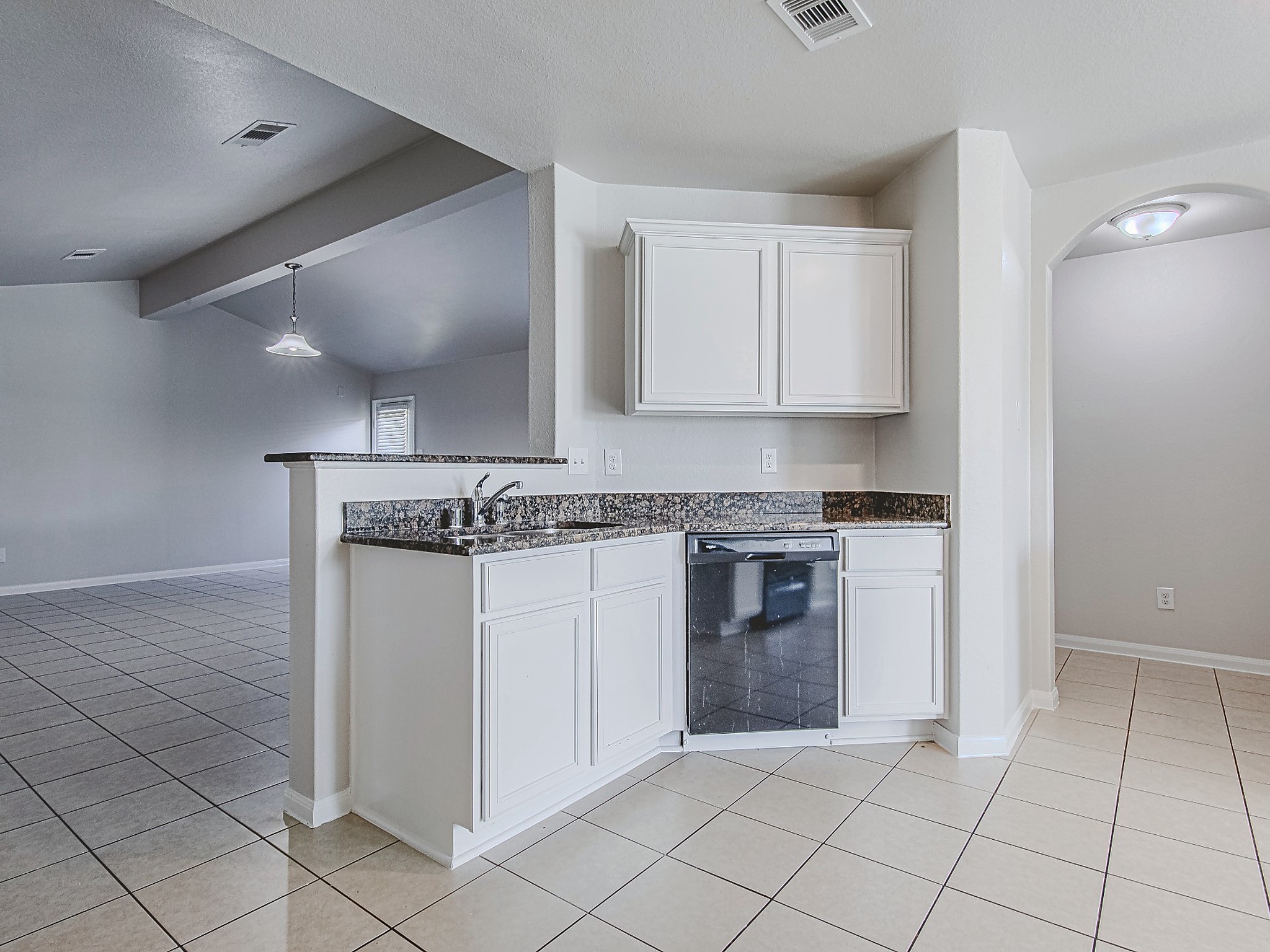 The kitchen peninsula provides additional counter space and a convenient connection to the living area, with a dishwasher tucked beneath the counter.