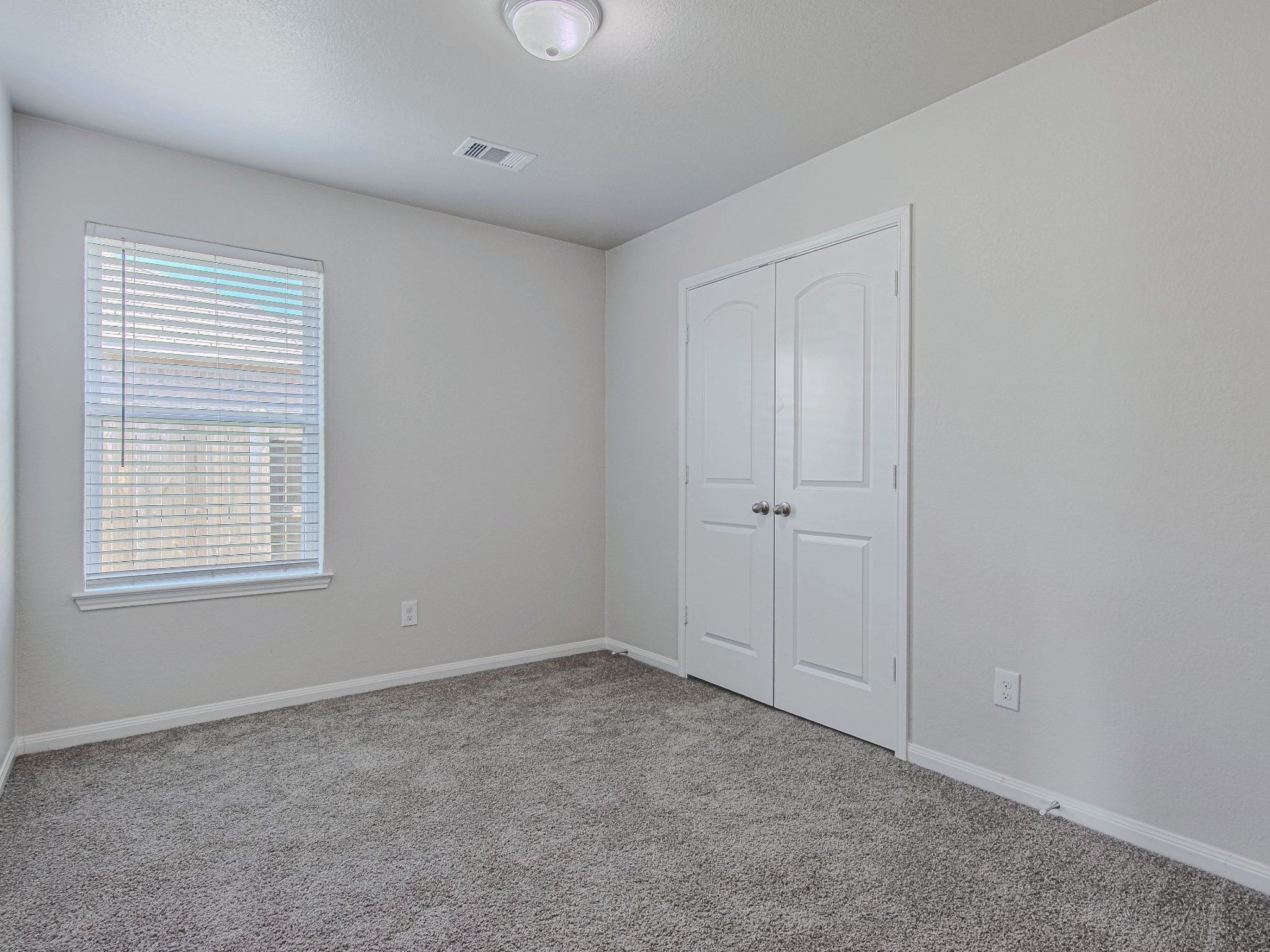 Another secondary bedroom offers carpet flooring, natural light, and closet storage, with room to personalize the space.