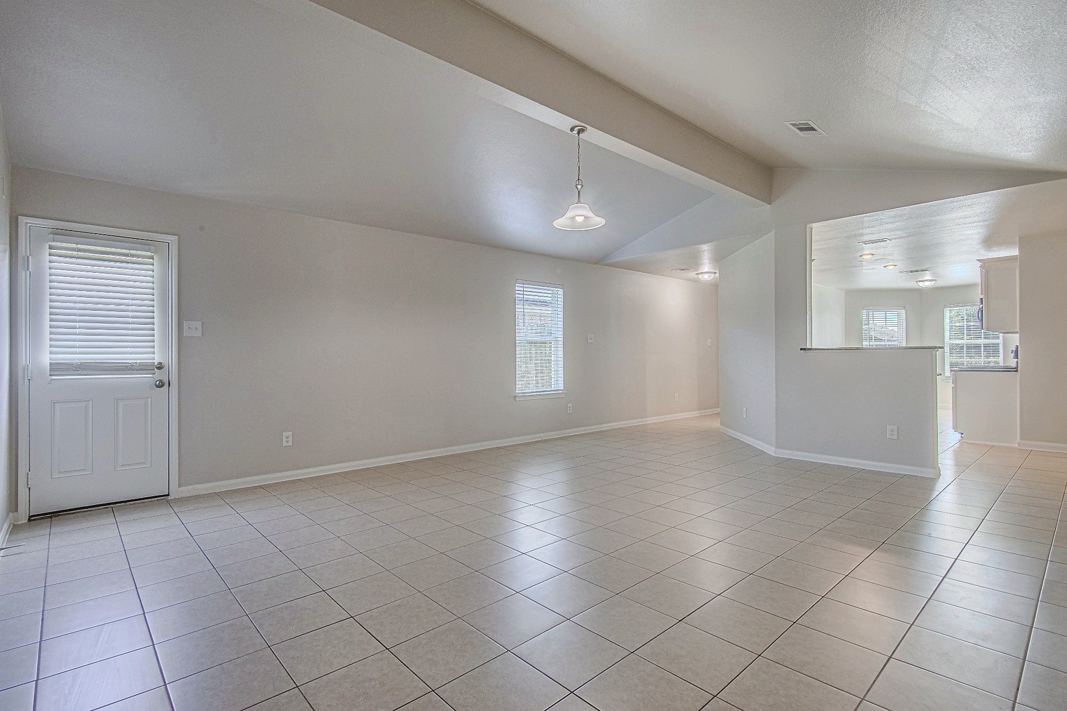 Natural light brightens this open living and dining area, complemented by tile flooring and neutral finishes that suit a variety of furnishings.
