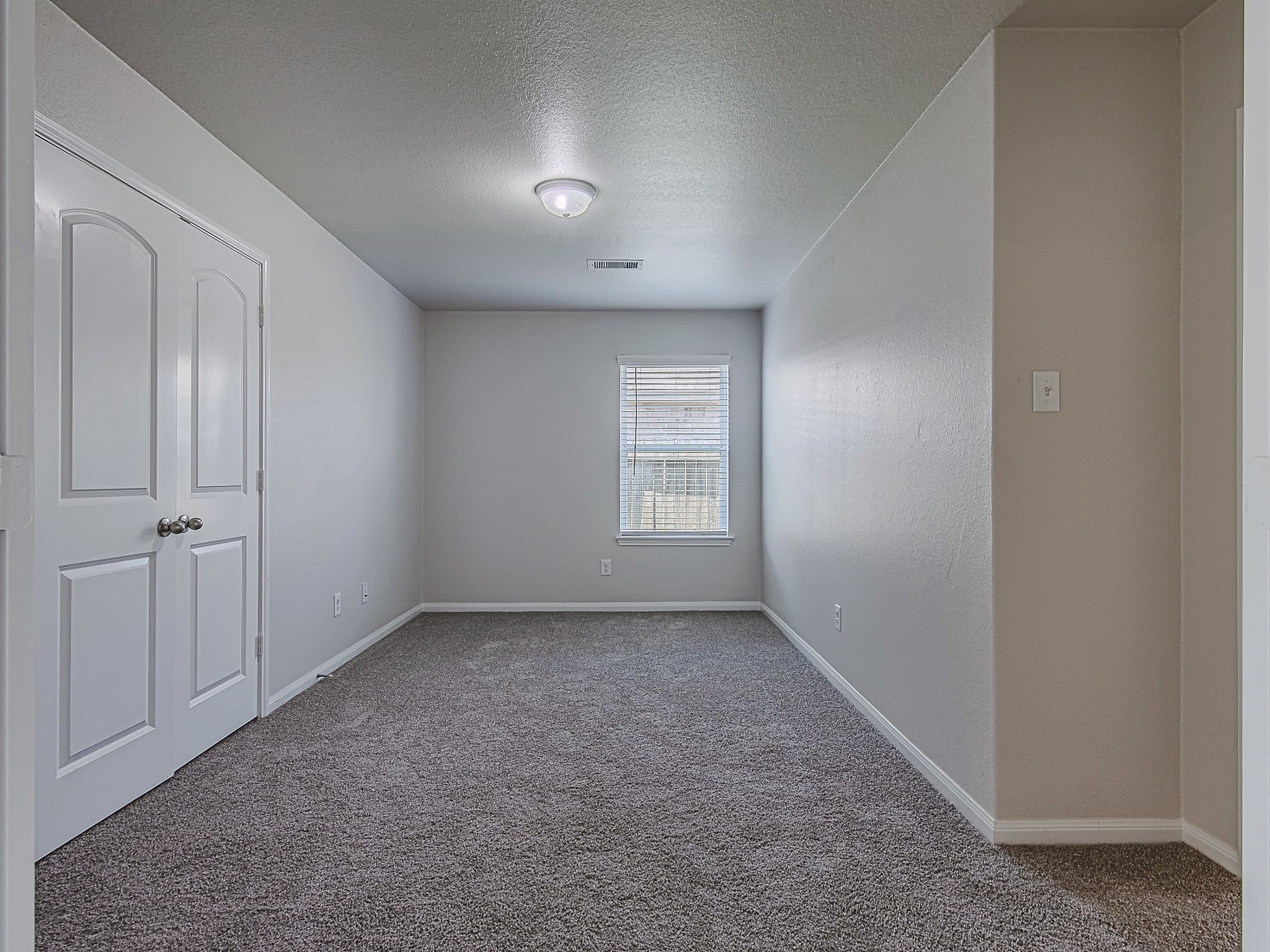 This additional carpeted room features a window and closet storage, offering flexible space to suit your needs.