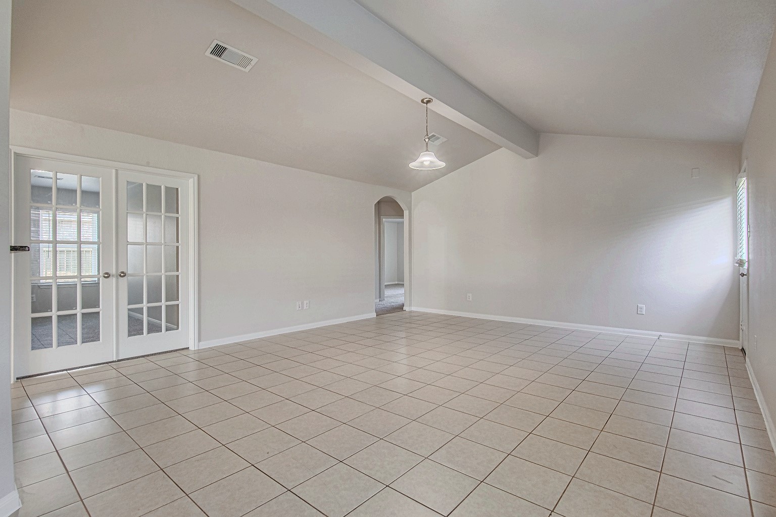 The living room features tile flooring, a ceiling fan, and backyard access, offering a comfortable space for everyday living.