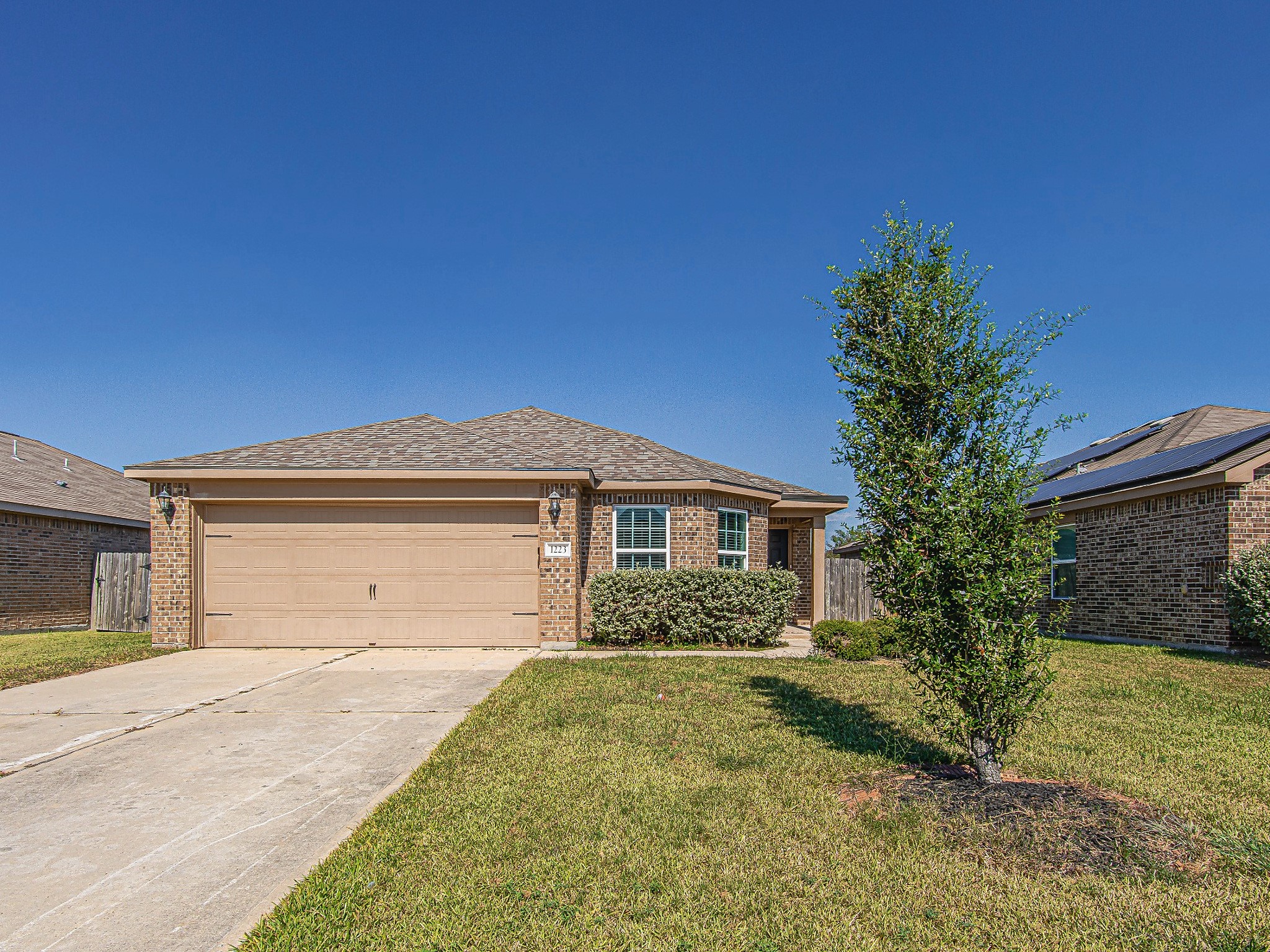 Welcome home to this single-story brick residence featuring a two-car garage, a covered front entry, and an inviting front lawn.
