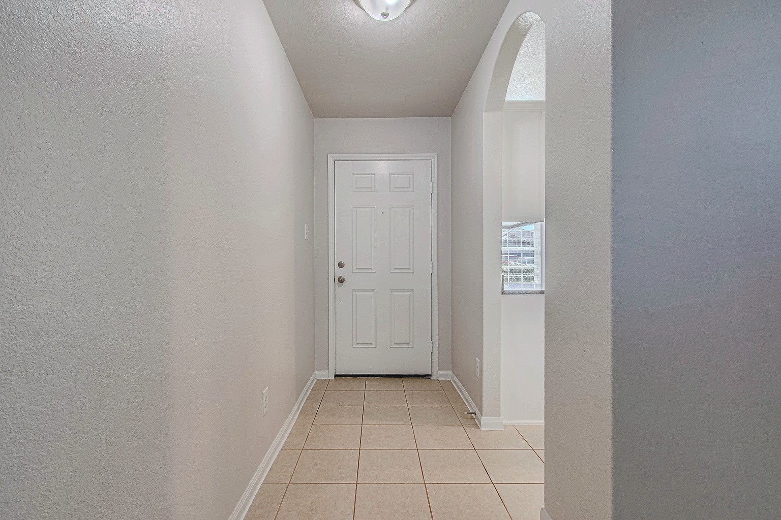 The tiled entry hallway offers a welcoming introduction to the home, with neutral walls and an easy-care floor.