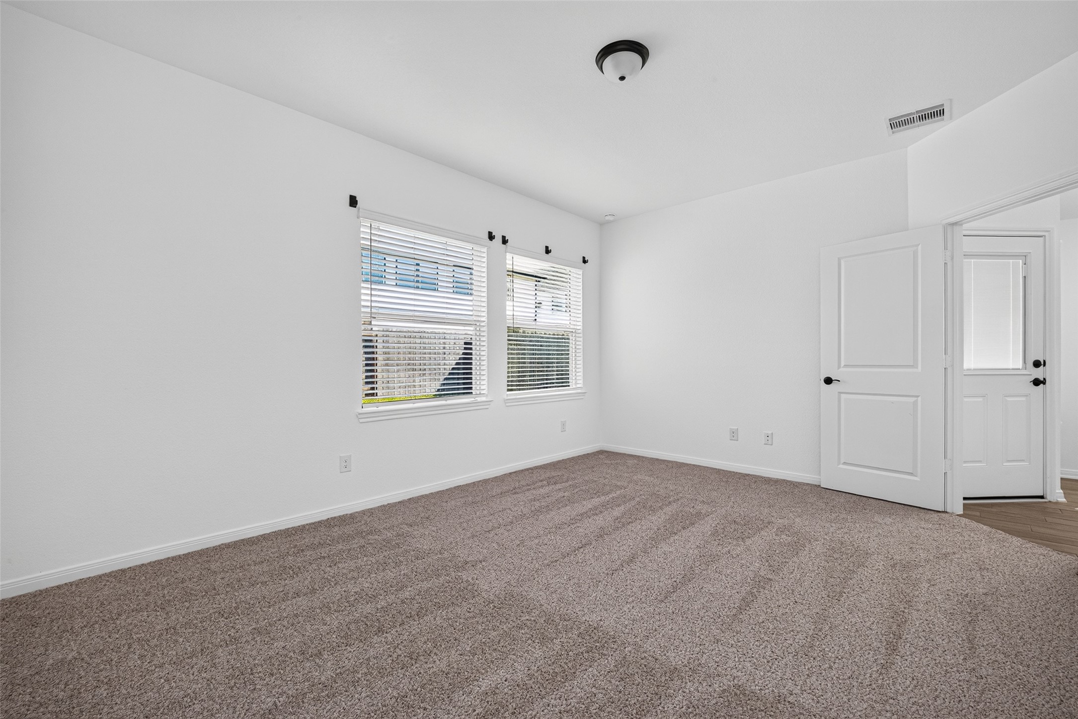 Primary bedroom at the end of the house with views of the backyard