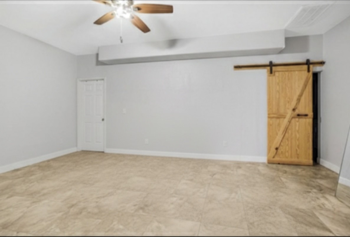 Primary bedroom in the casita. Behind the barn door is the utility room. The enormous closet is behind the white door.