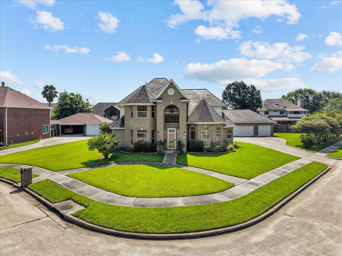 Prominently positioned on a curve with wrap-around sidewalks, this stately two-story home offers an impressive arched entryway.